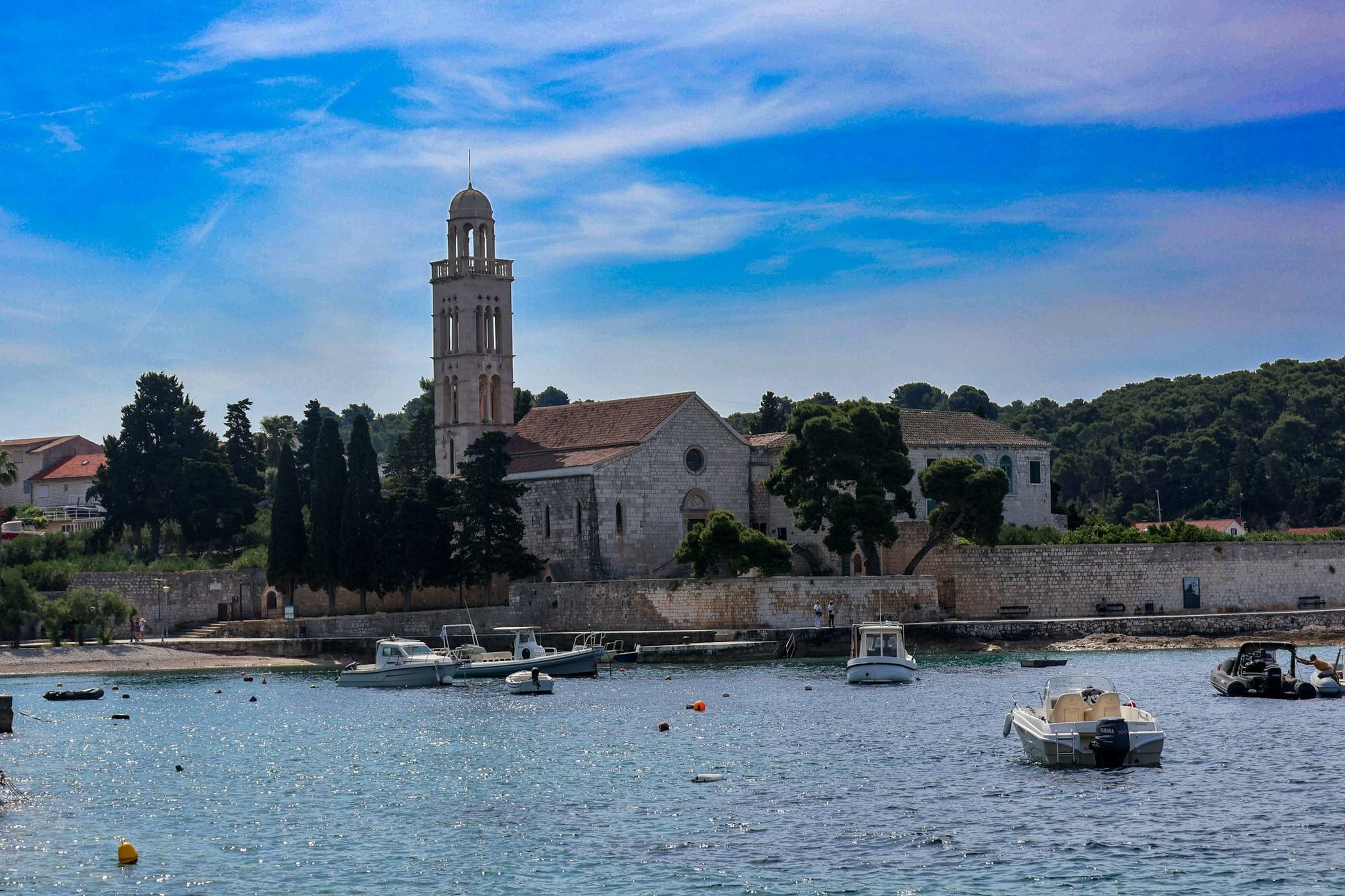 Boats in Hvar Town harbour in front of a church