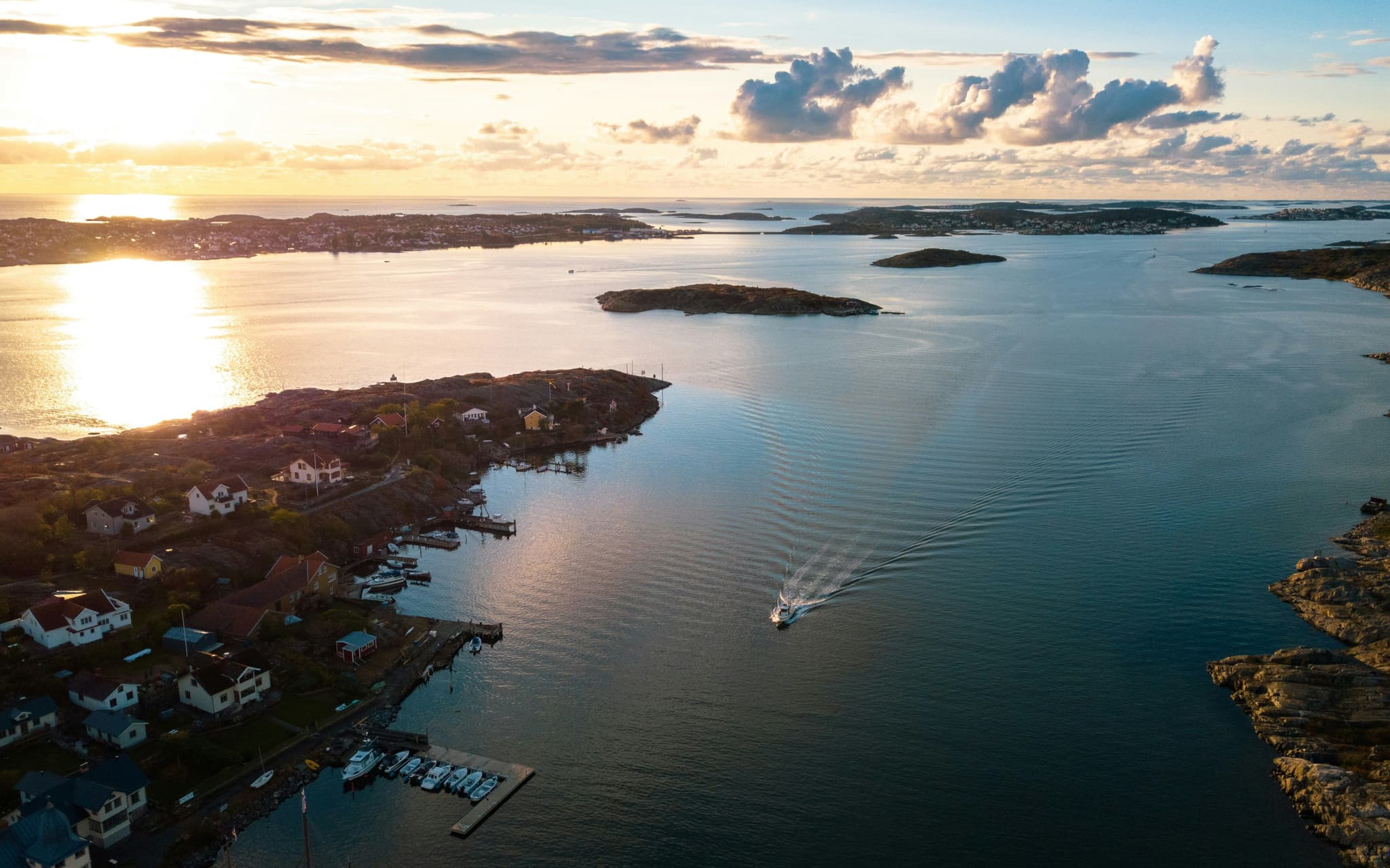 Stockholm archipelago from above water and sunset and island and small boat visible