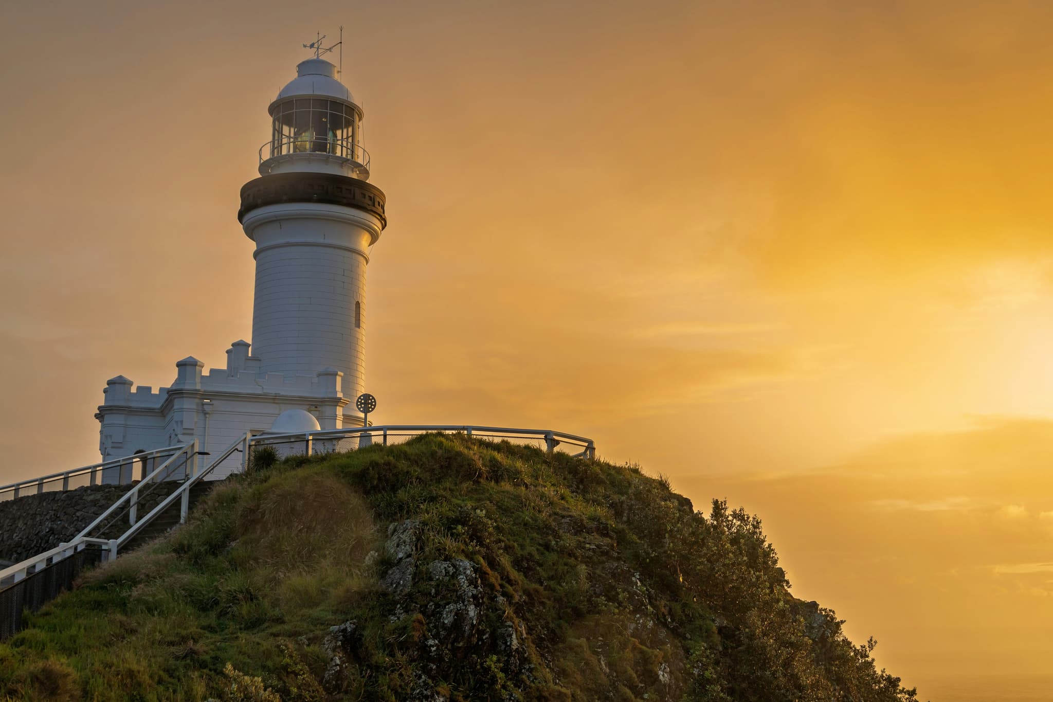 Cape Byron Lighthouse at sunset above the headland in Byron Bay, New South Wales