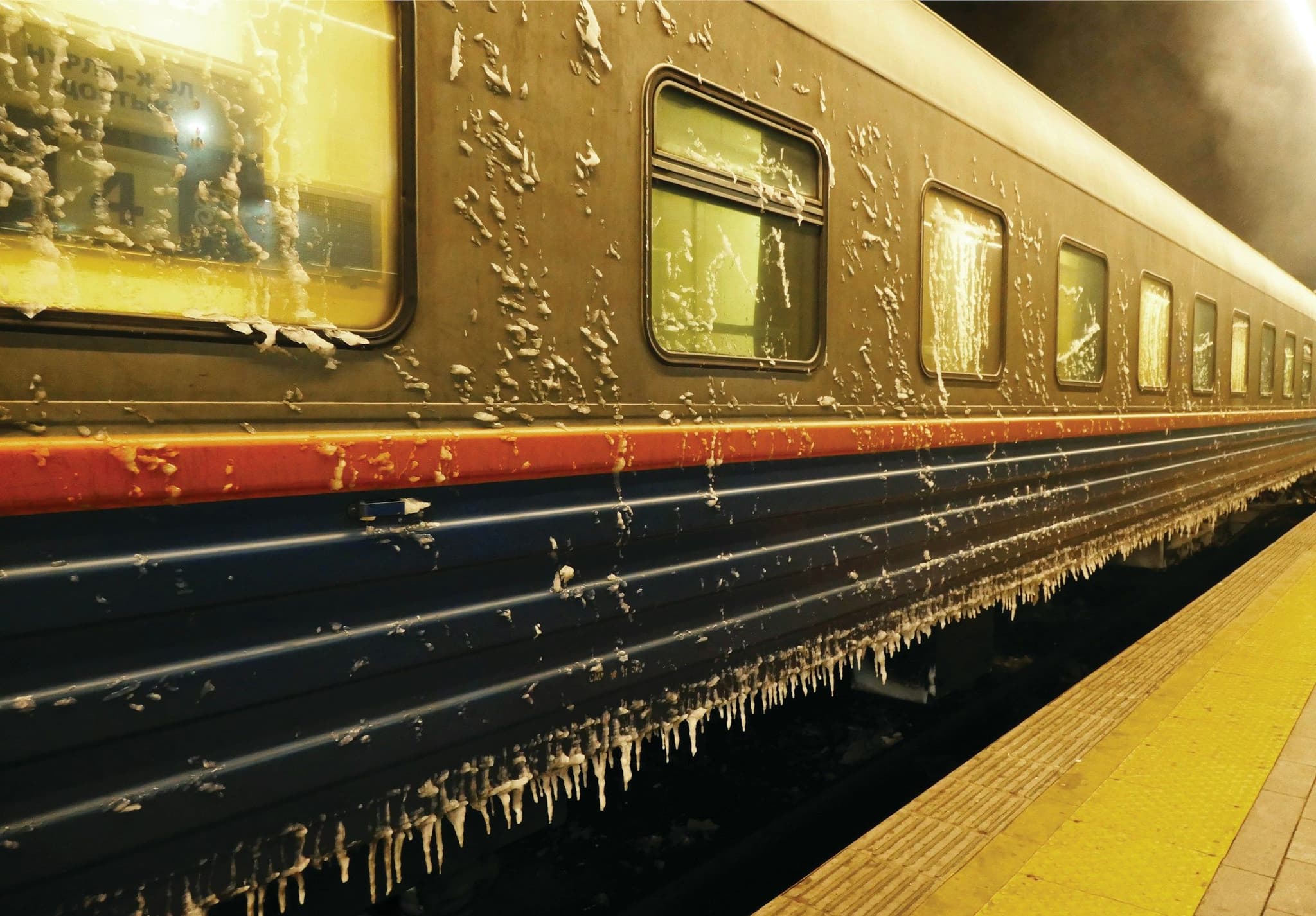 A passenger train covered in ice and snow