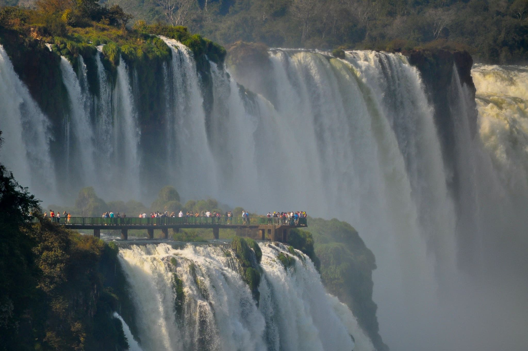 Visitors on a walkway looking out over Iguazú Falls