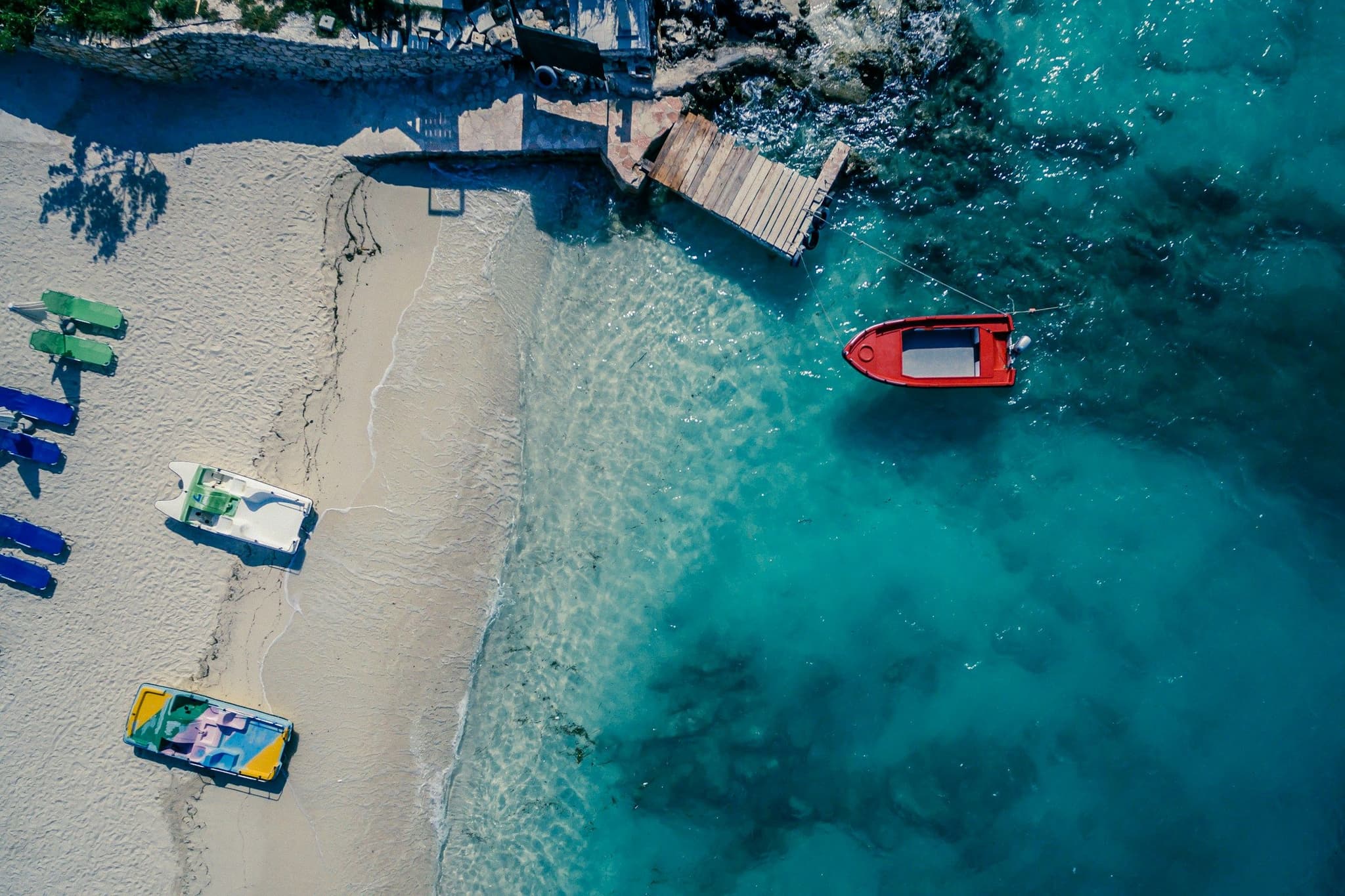 A red boat on clear water off the beach at Ksamil