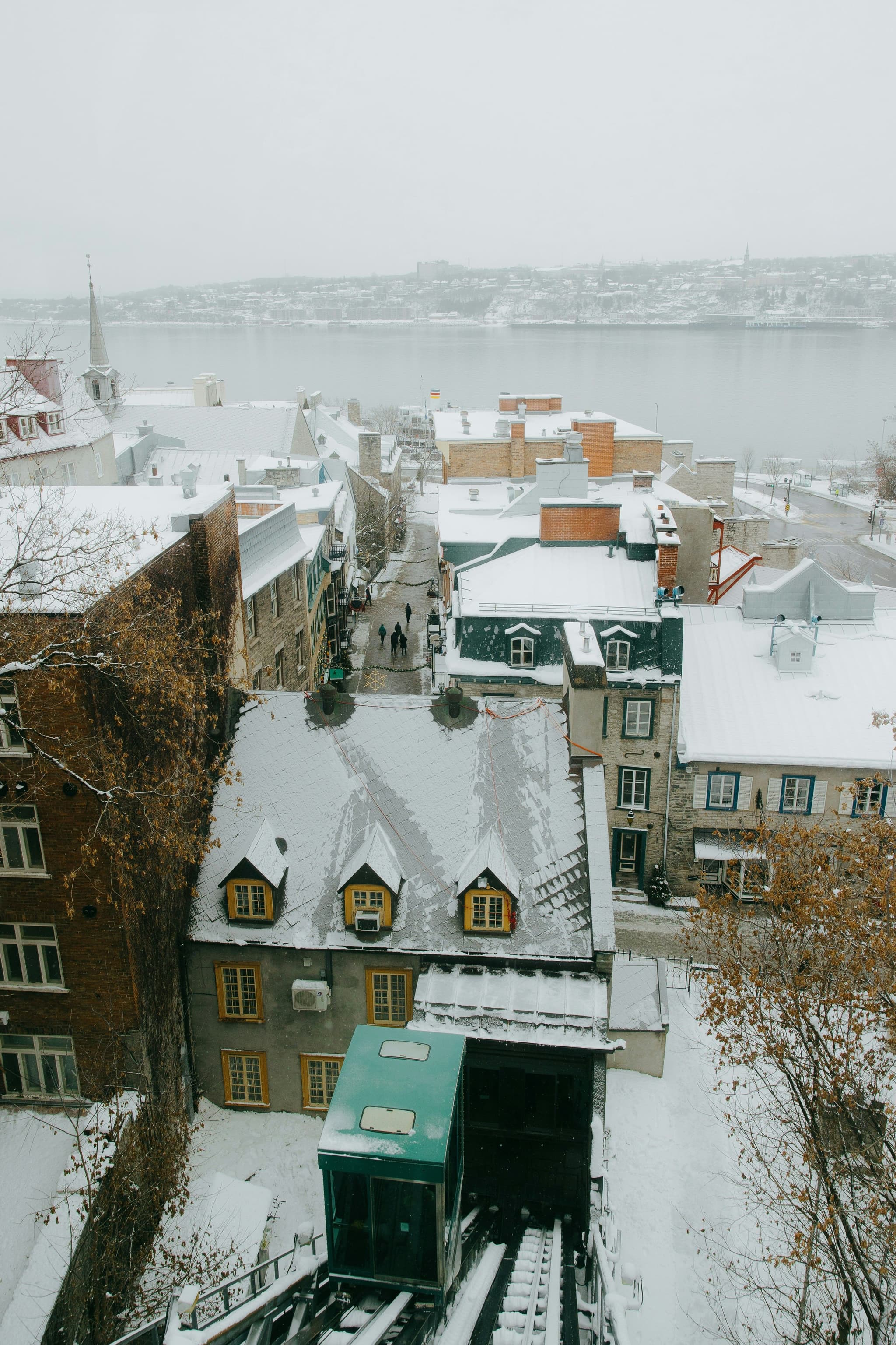 A snowy street in Old Québec lined with historic stone buildings, near the funicular that connects the Upper and Lower Town.