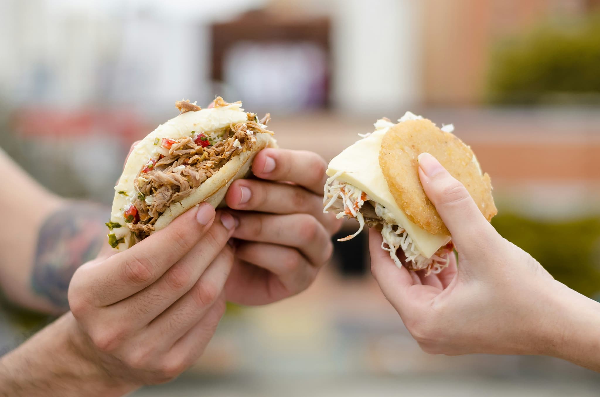 Hands holding arepas