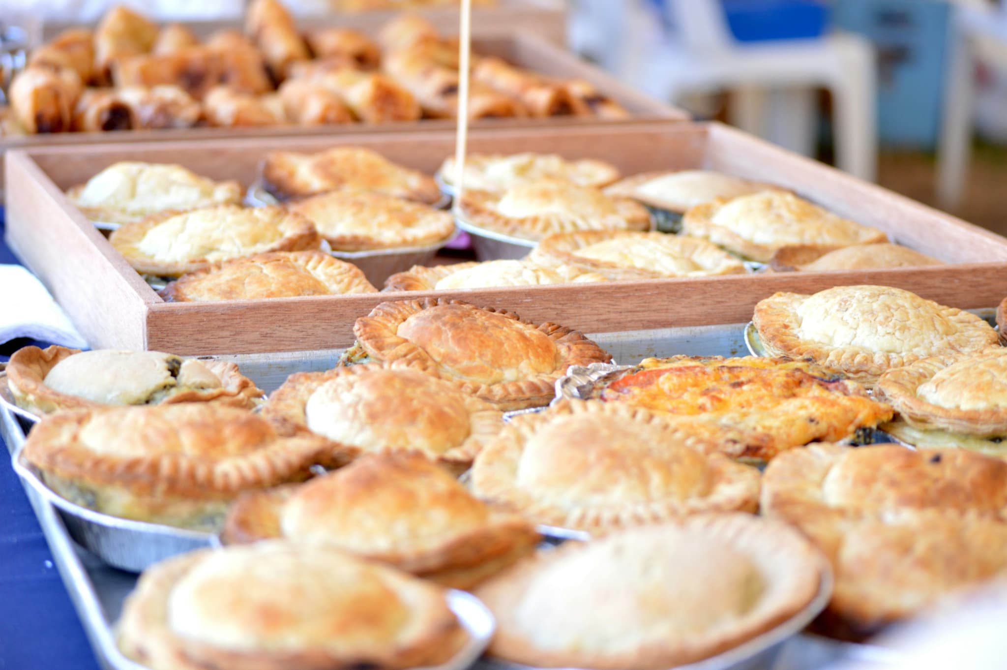 Meat pies next to each other on a tray in a bakery