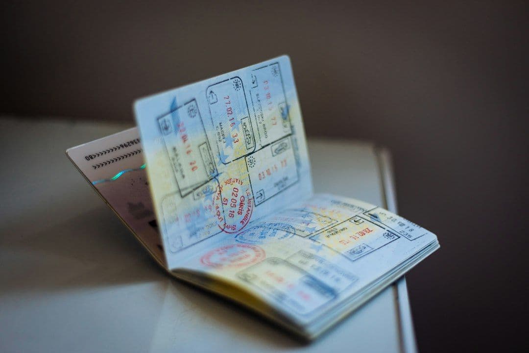 An open passport with multiple travel stamps on its pages.