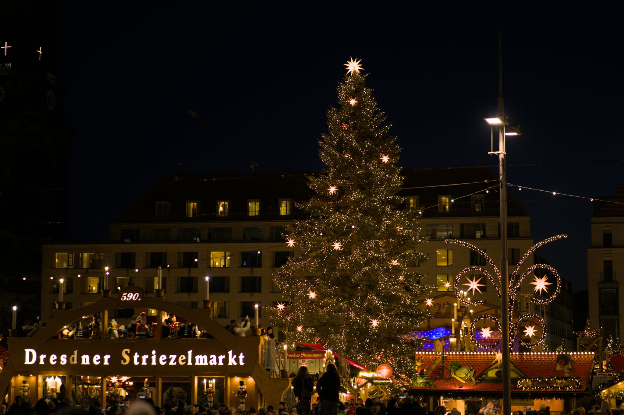 A lit Christmas tree at Dresden's Striezelmarkt at night