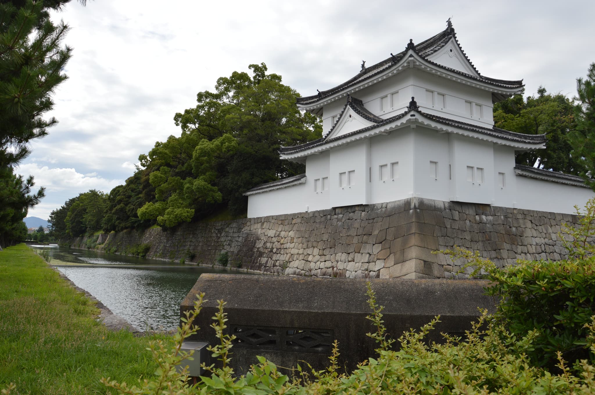 Kyoto's Nijo Castle: a white small temple like building on the water in a green area