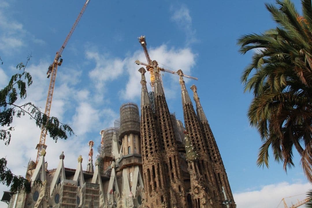 The Sagrada Família in Barcelona with construction cranes still visible against a blue sky