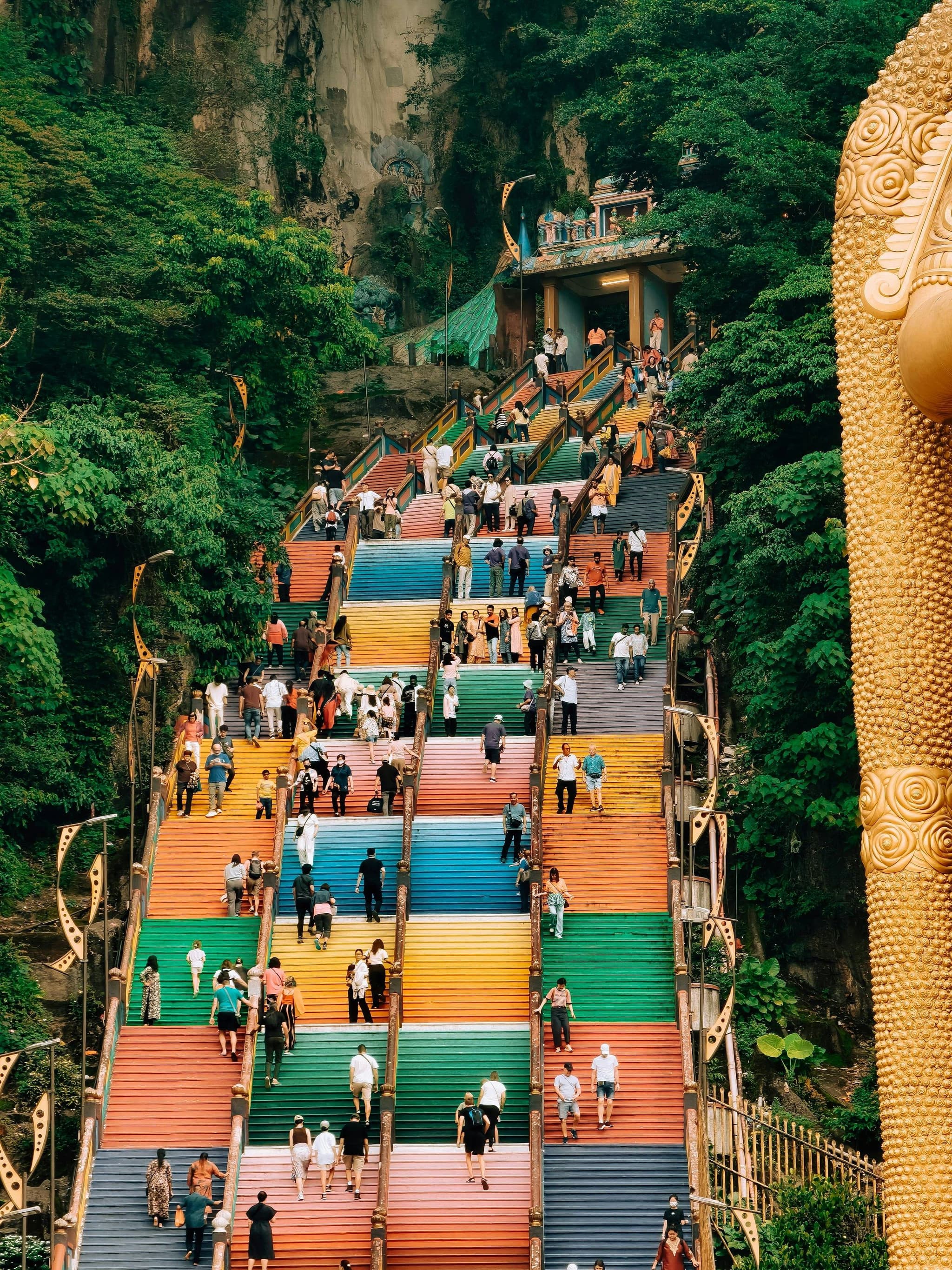 Visitors on the rainbow-painted steps at Batu Caves
