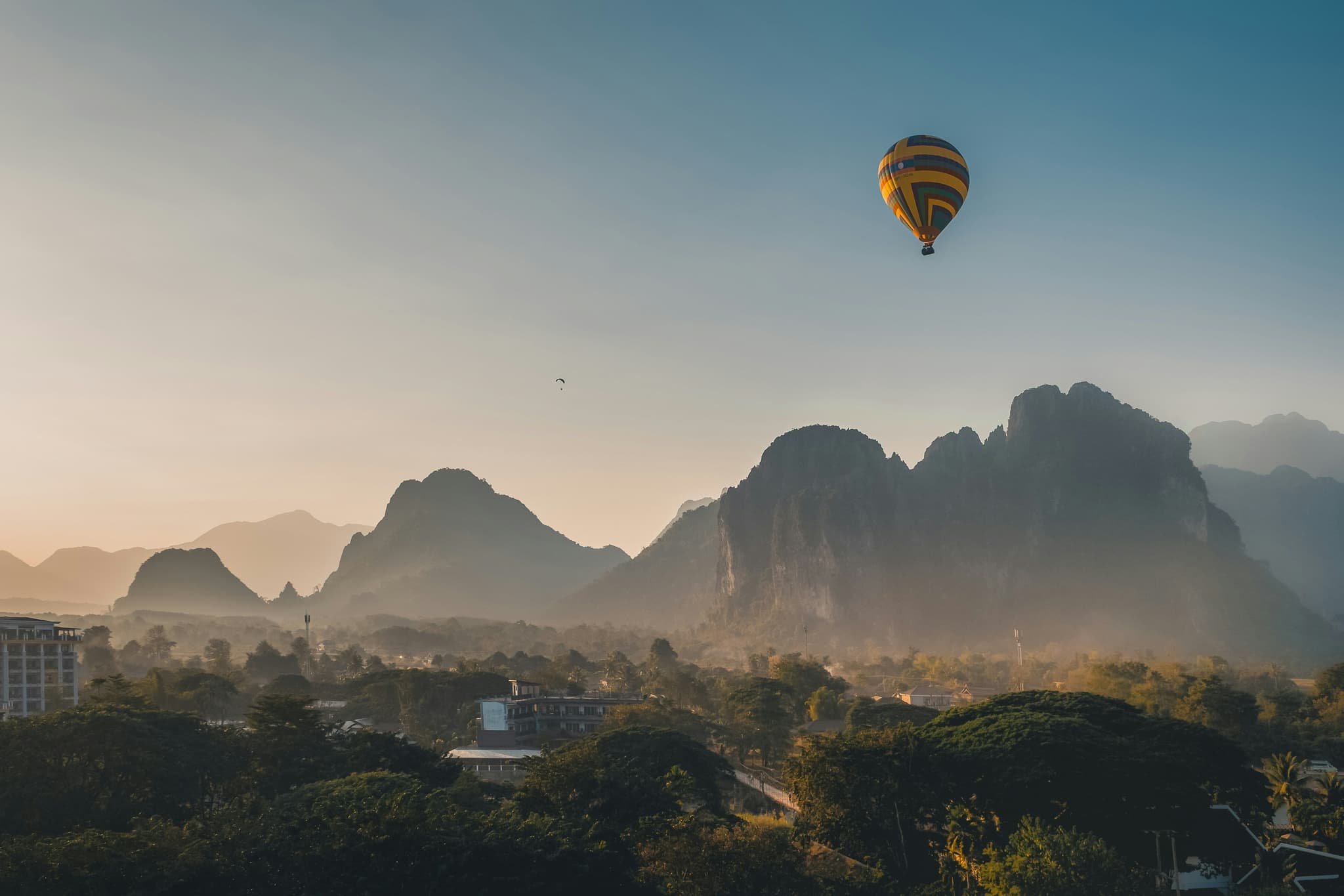 View of Vang Vieng during sunset with a hot air balloon in the air