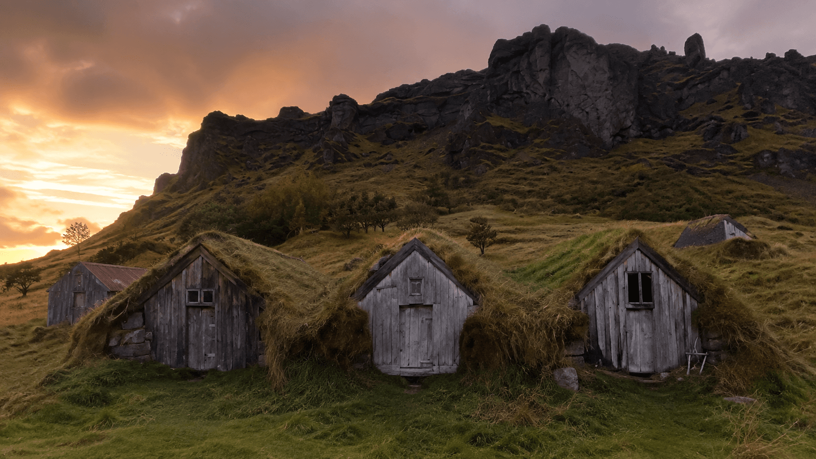 wooden small houses in the grass during sunset Huldufólk iceland