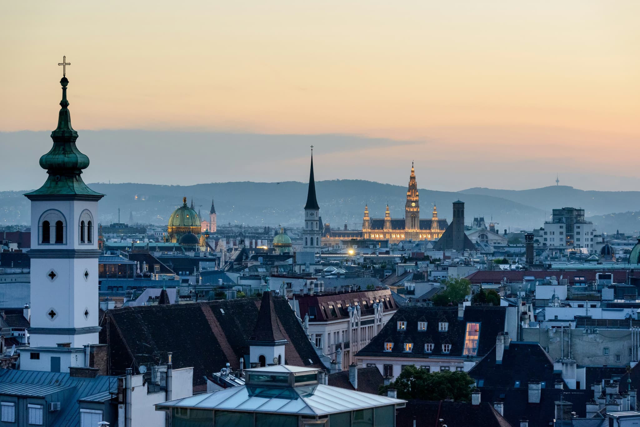 Aerial view of the city and church of Vienna during sunset with orange sky