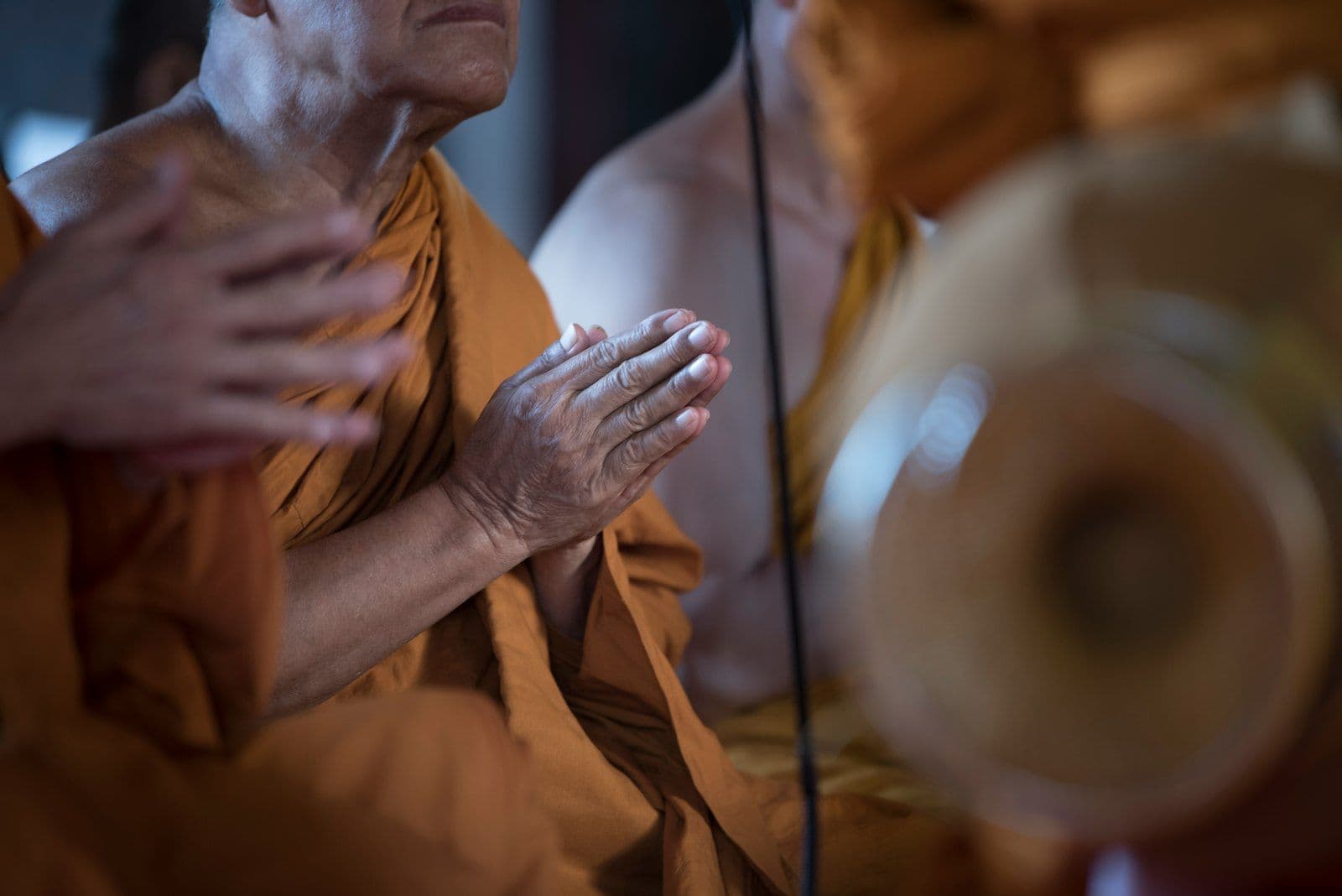 A monk in Thailand with hands pressed together in prayer