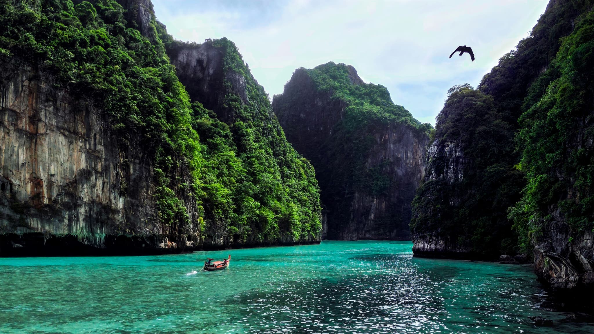 Turquoise water with boats and green limestone cliffs at Koh Phi Phi