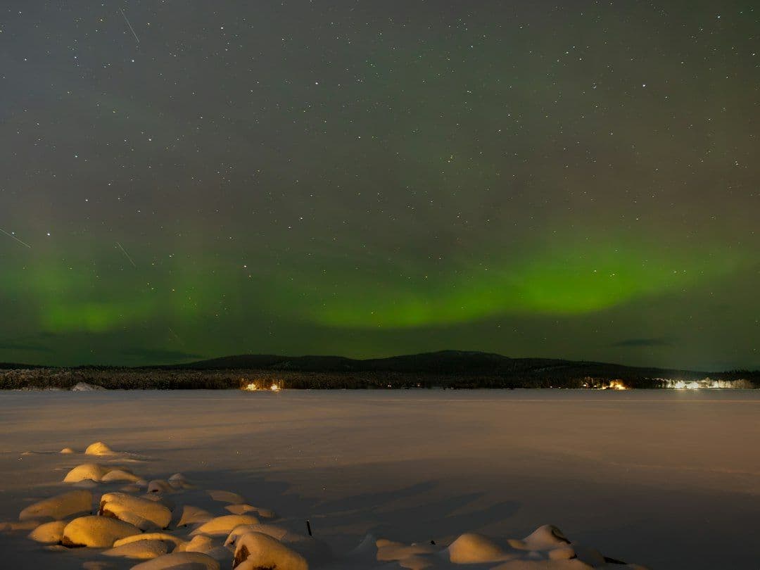 The aurora borealis glowing over frozen Lake Inari in northern Finland.