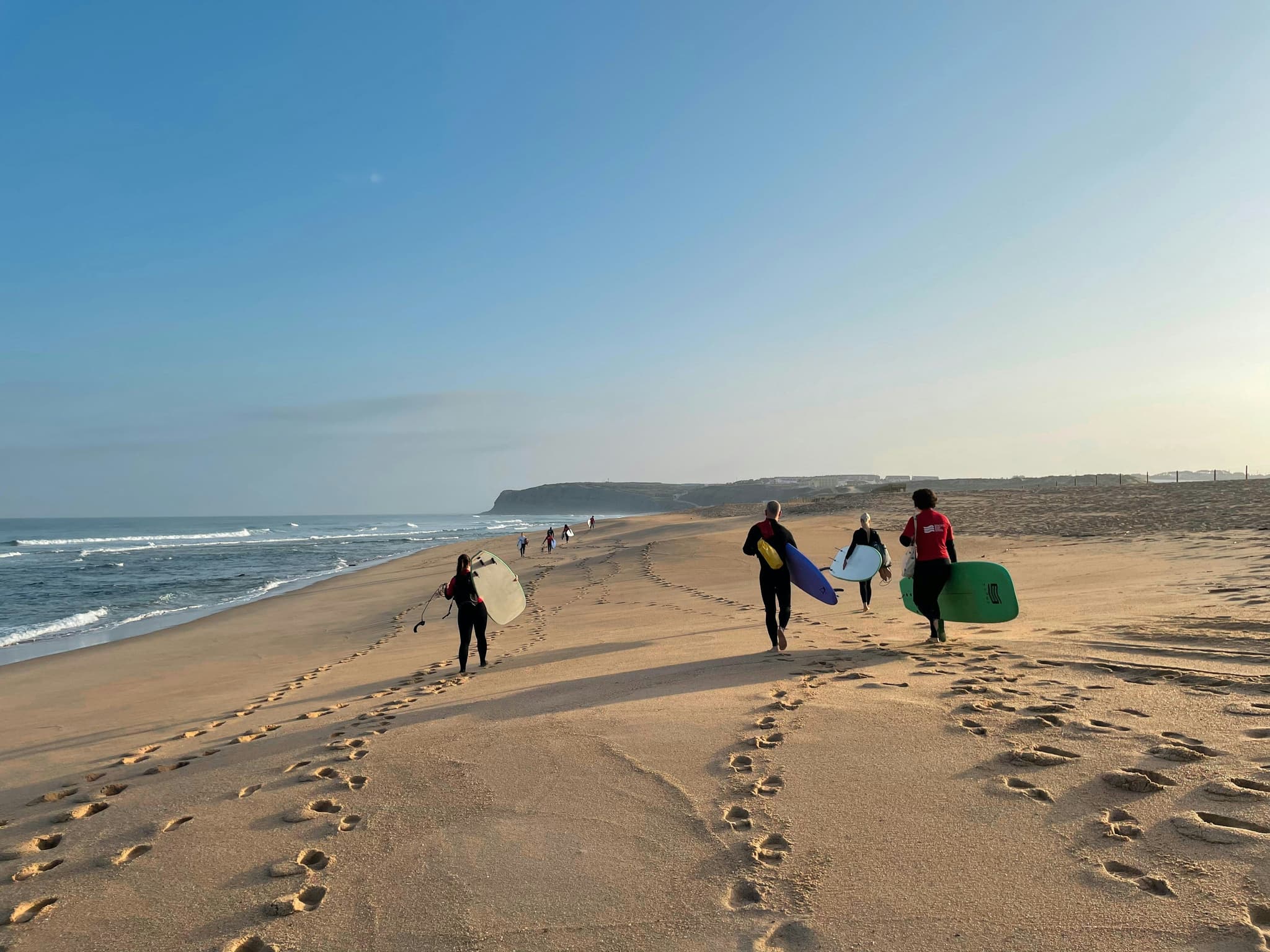 Surfers walking on the sand at Praia do Amado on Portugal's west coast