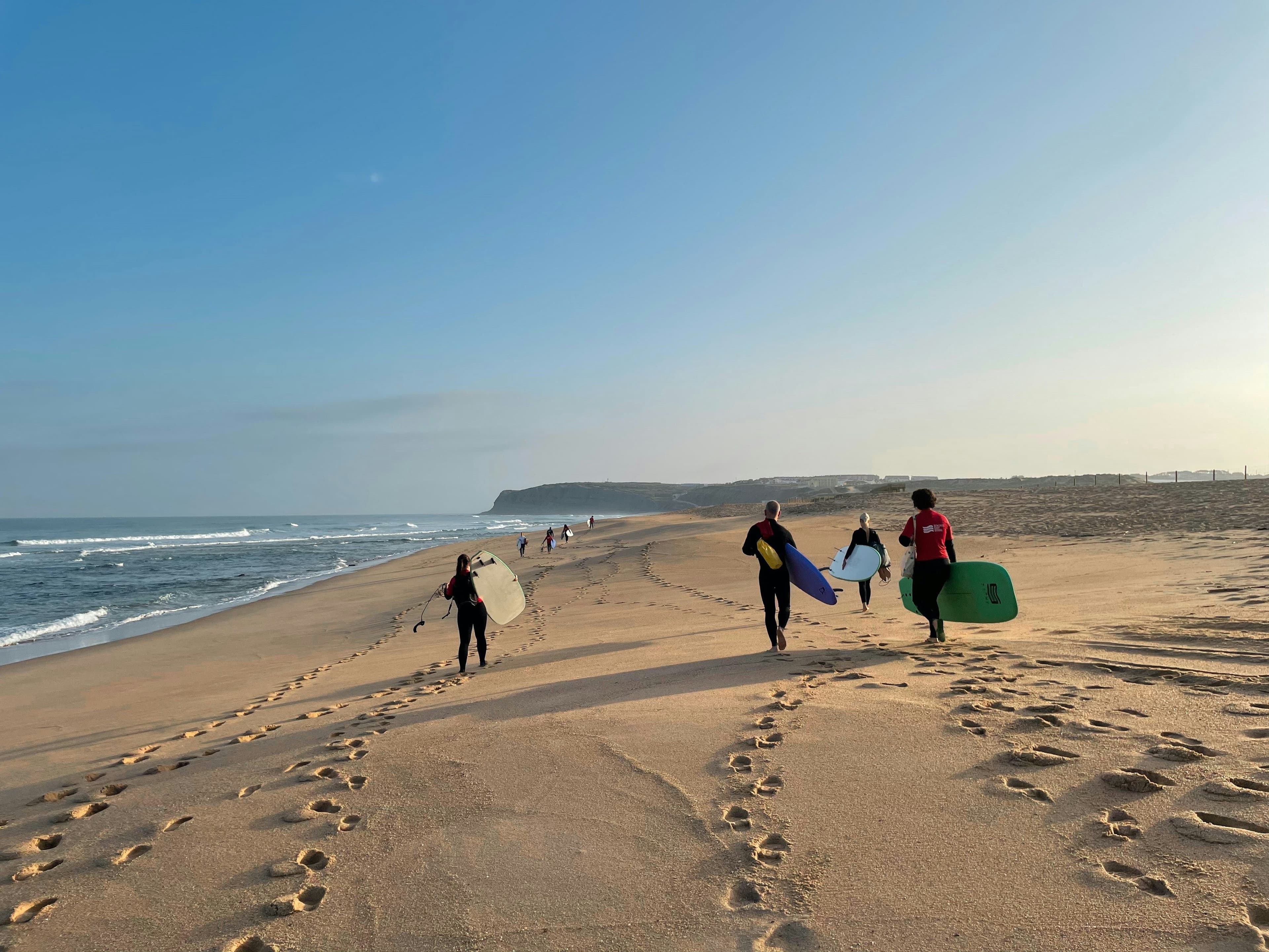 Surfers walking on the sand at Praia do Amado on Portugal's west coast