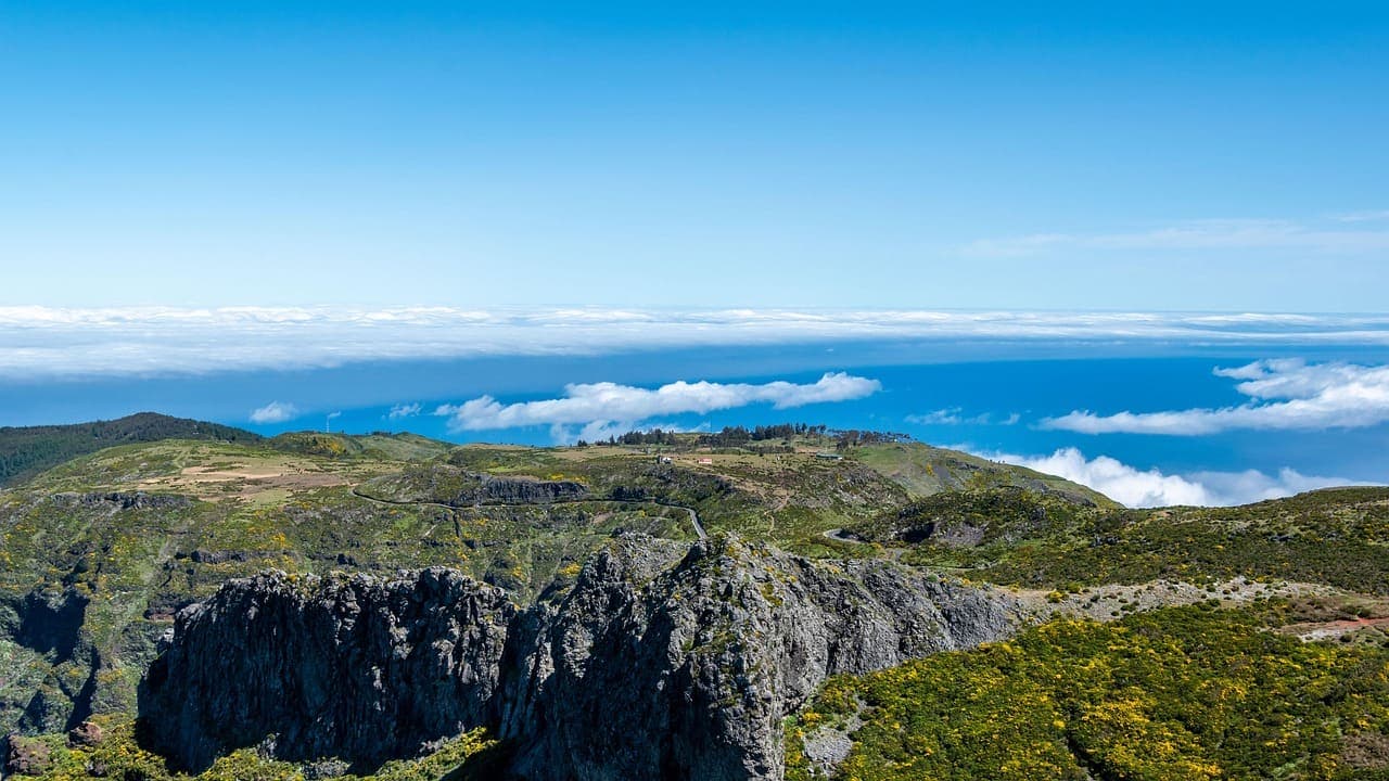 Mountainous landscape in Madeira with steep green cliffs overlooking the Atlantic Ocean.