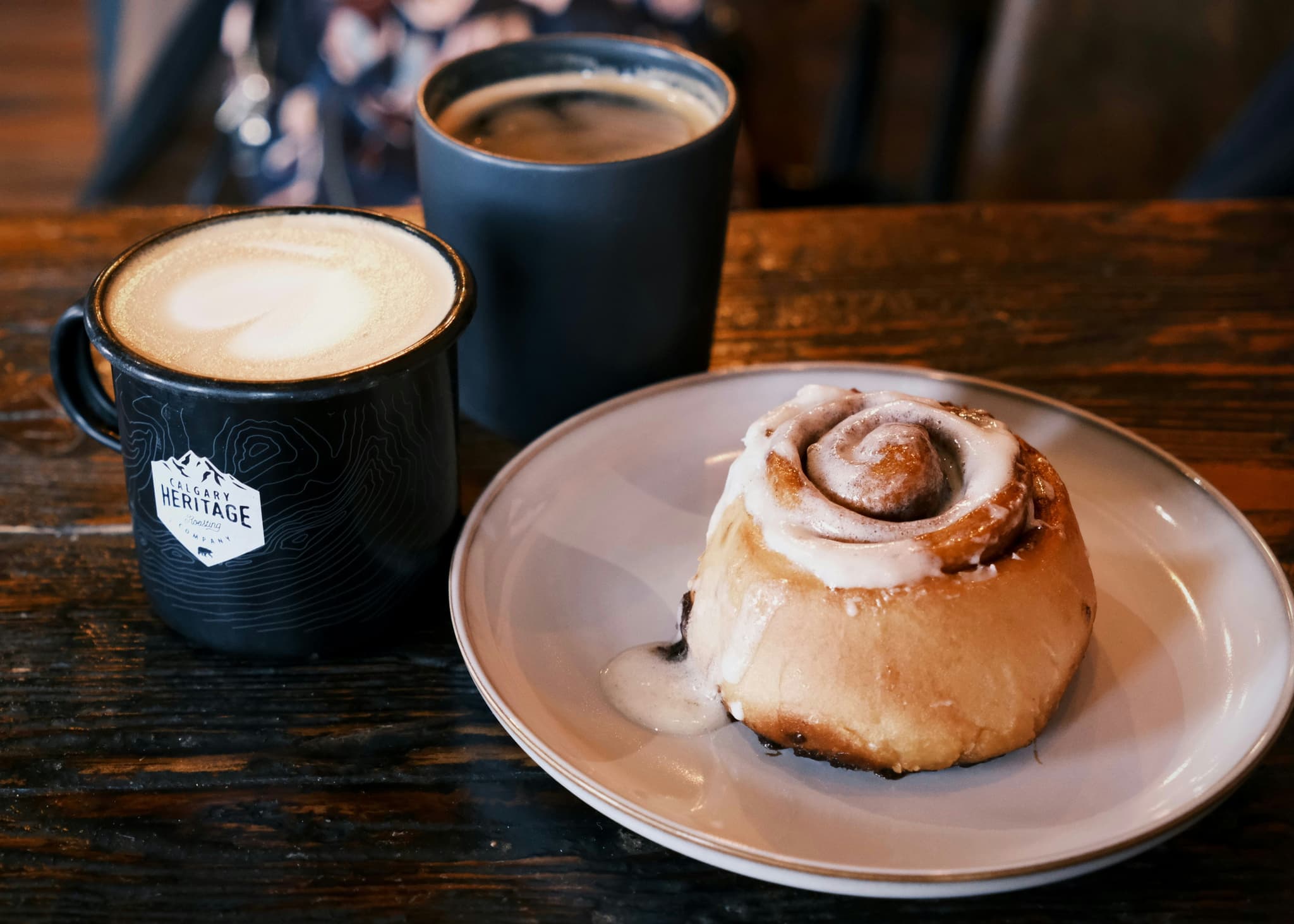 A cinnamon bun and coffee cup on a café table, classic Swedish fika
