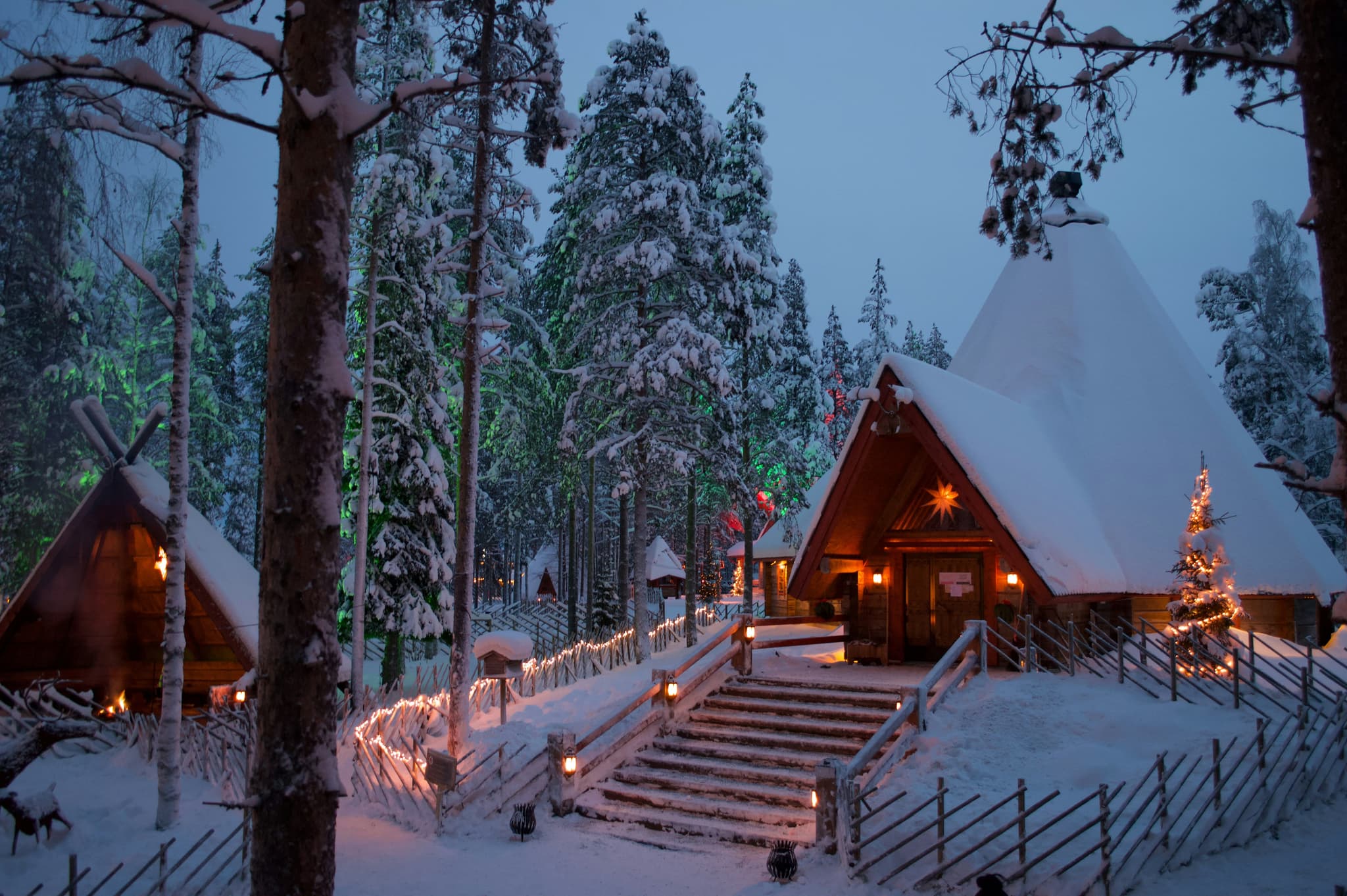 Cute snow covered houses at night decorated with christmas lights in Rovaniemi