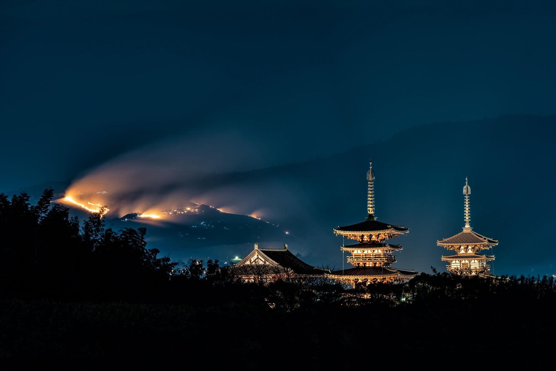 Two lit temples in the dark during Japanese matsuri