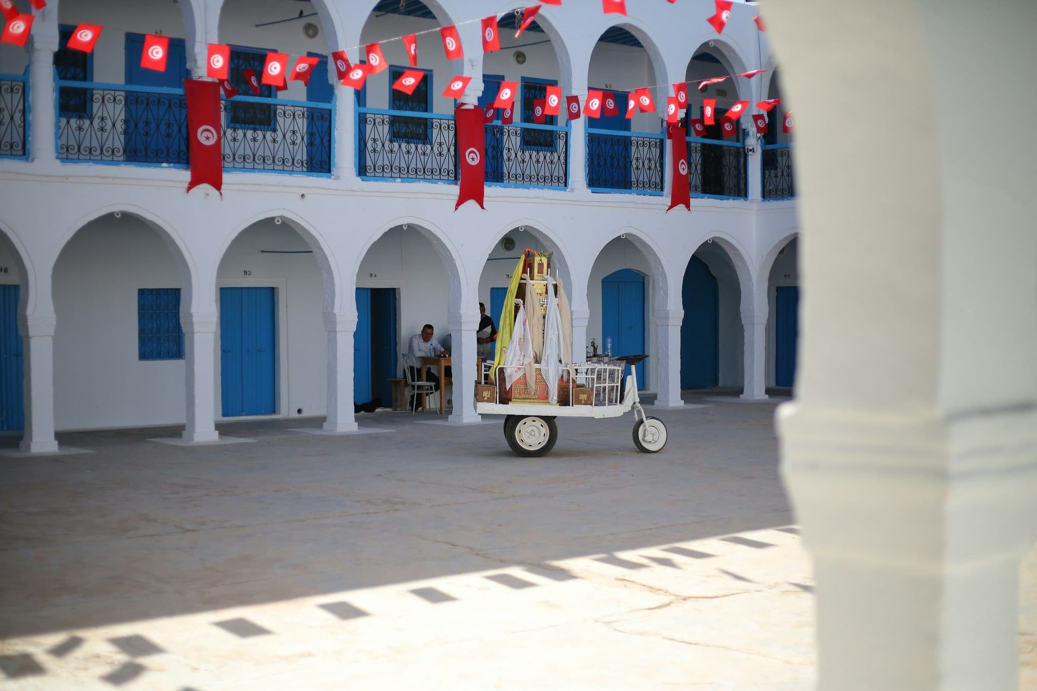 White arches and blue doors in the courtyard of El Ghriba synagogue on Djerba