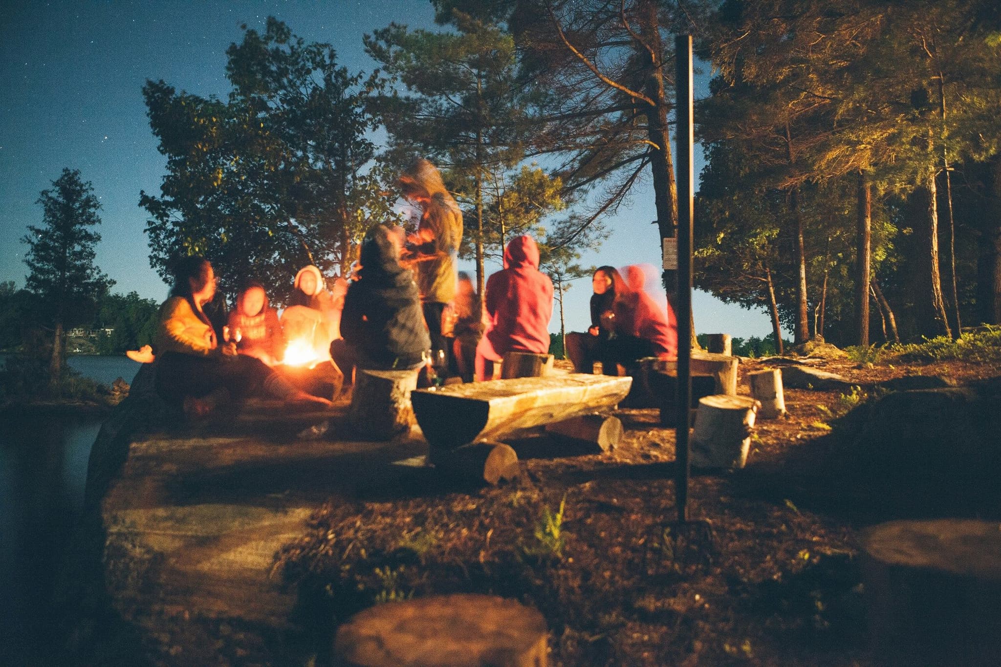 People sitting by a bonfire in the forest