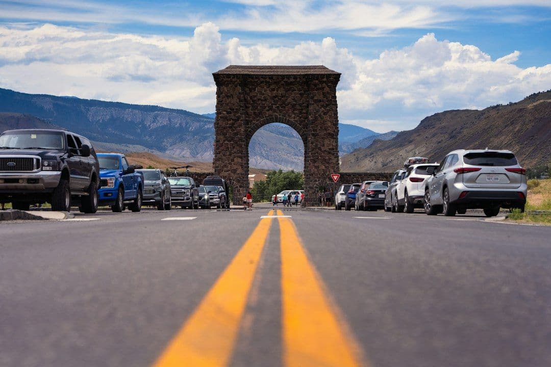 Cars lined up at the Roosevelt Arch, the entrance gate to Yellowstone National Park.