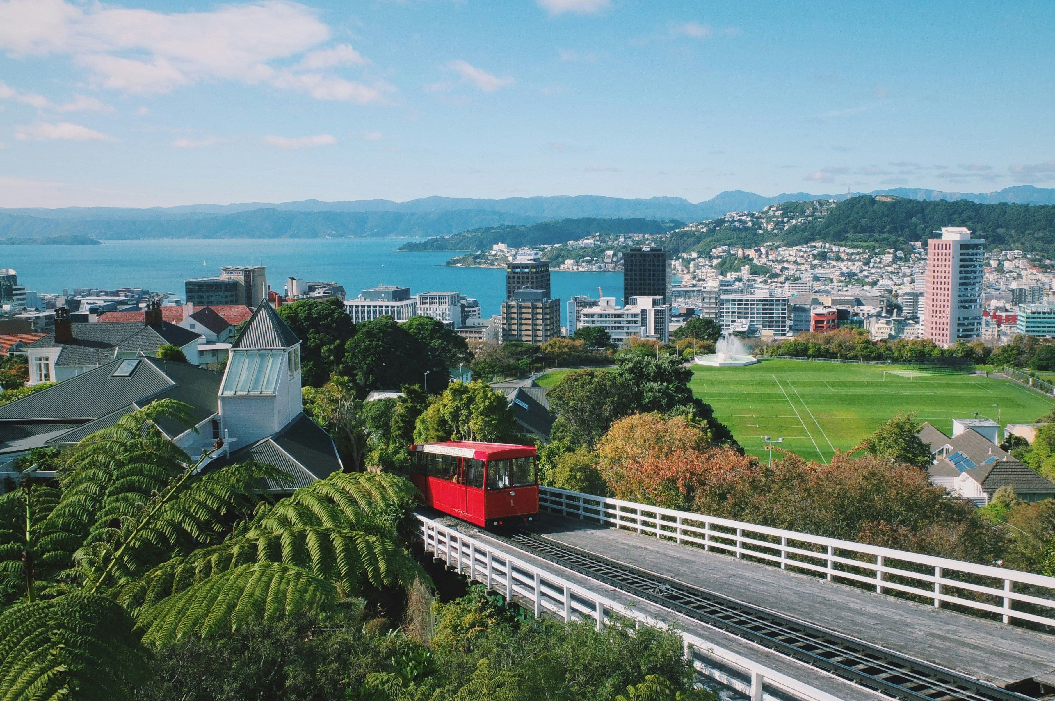 Wellington city in new zealand with a red tram and residential buildings overlooking the ocean