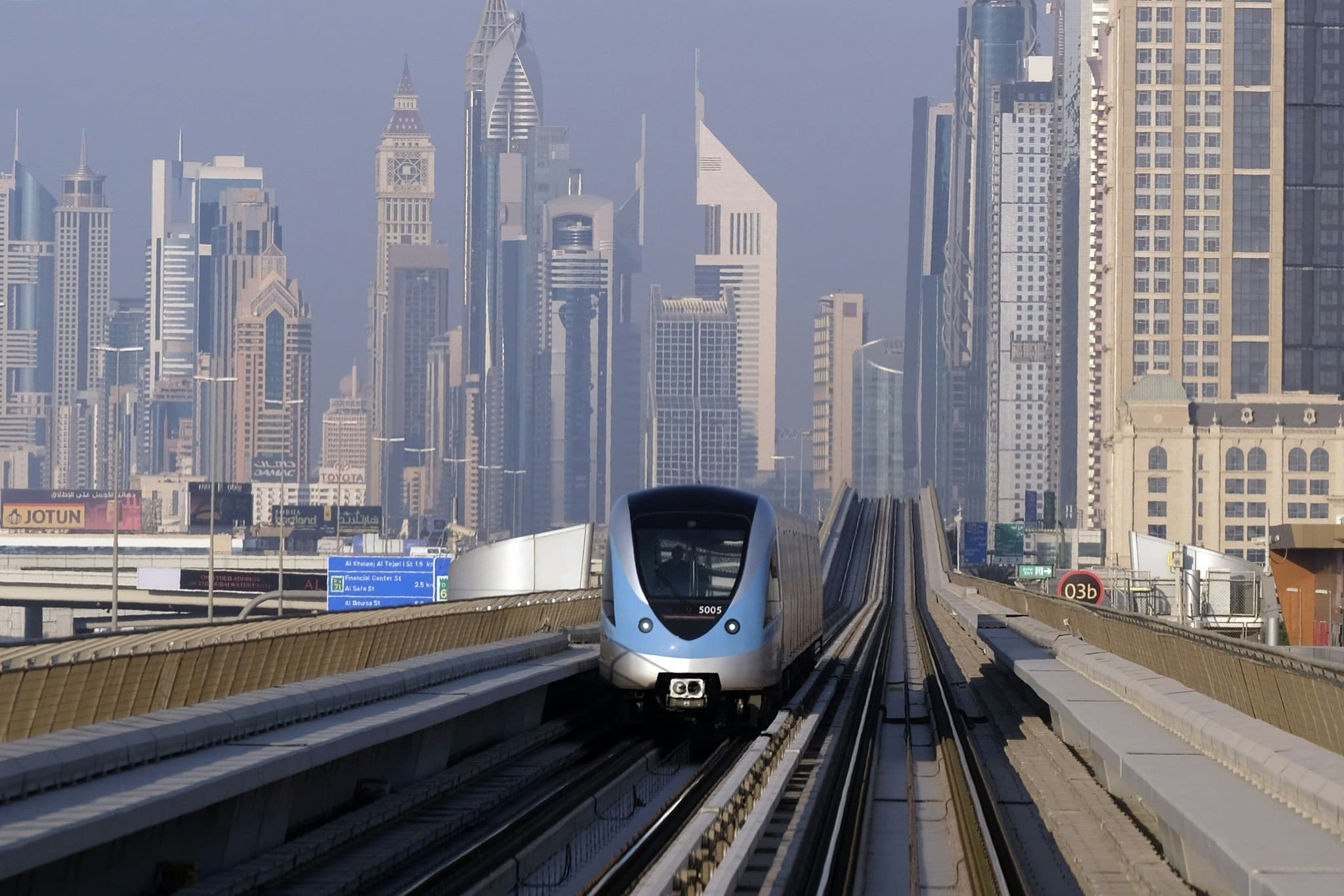 Metro on rails with skyscrapers in the background.