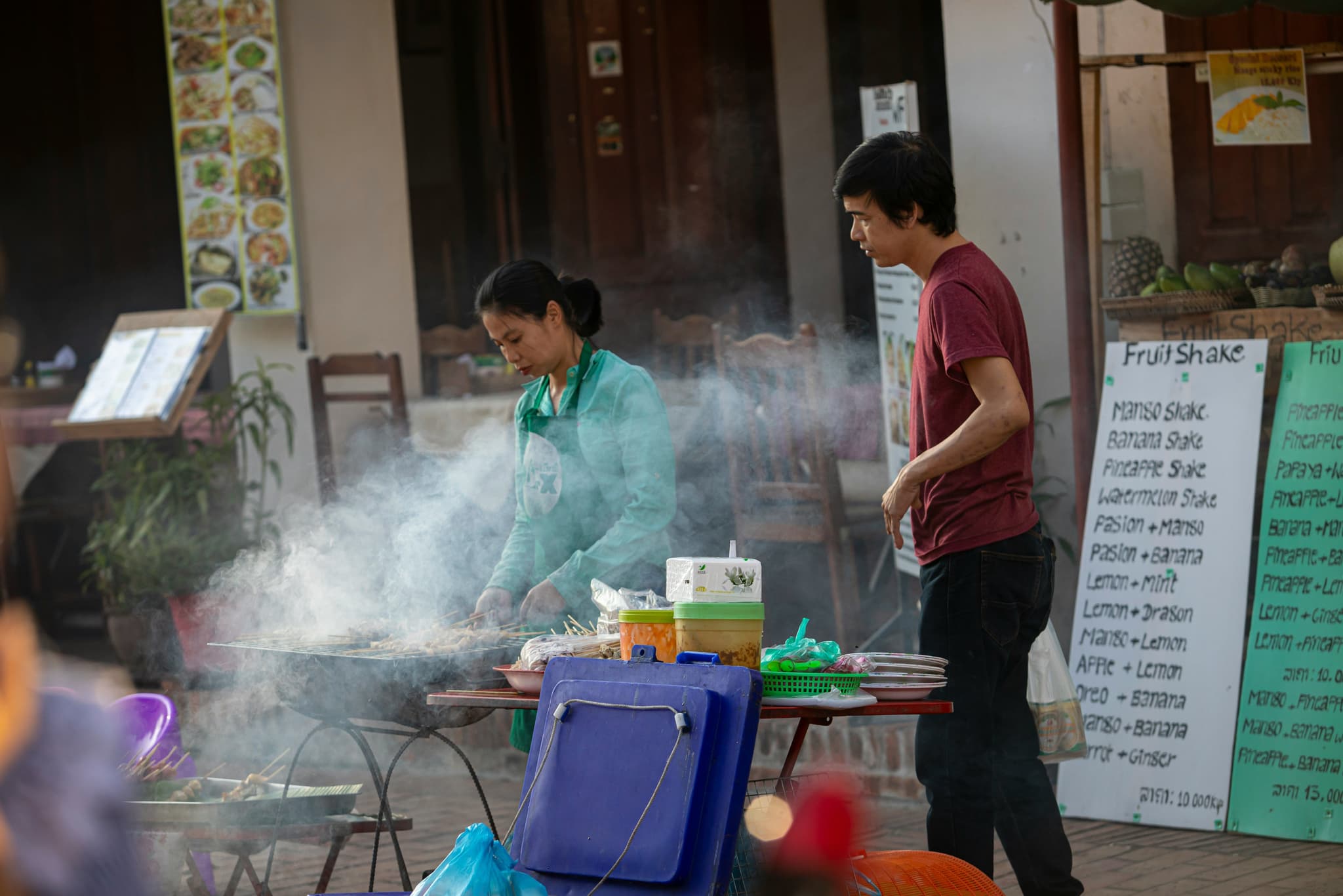 locals in laos making food in a street food stall