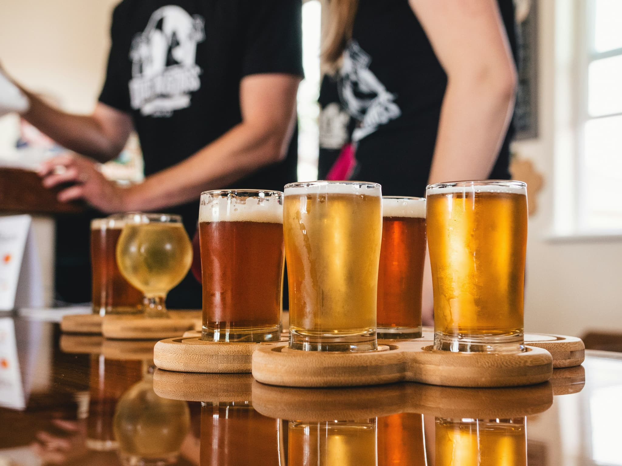 Different sizes of glasses of beer and two people