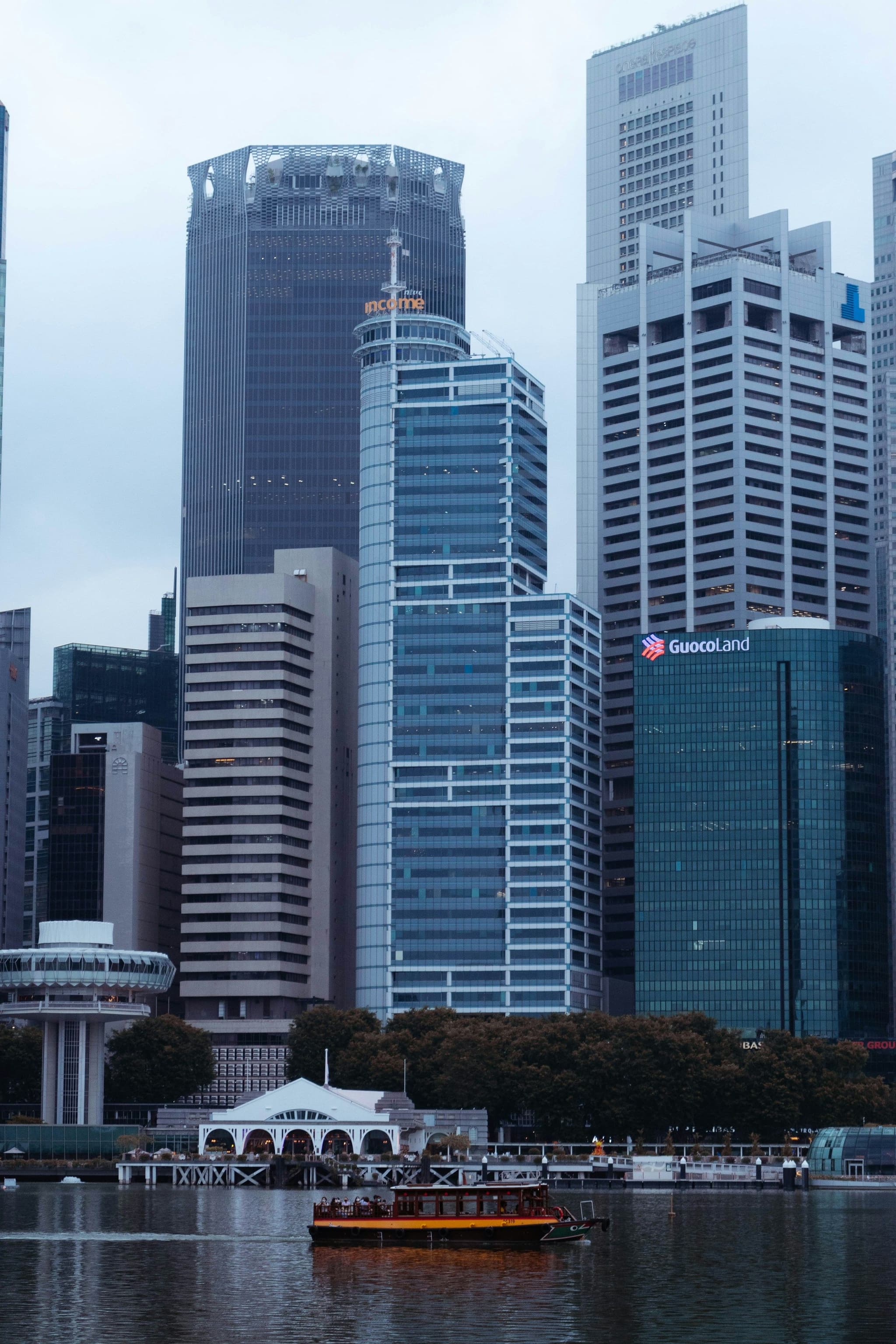 A river cruise boat passing tall buildings in the evening