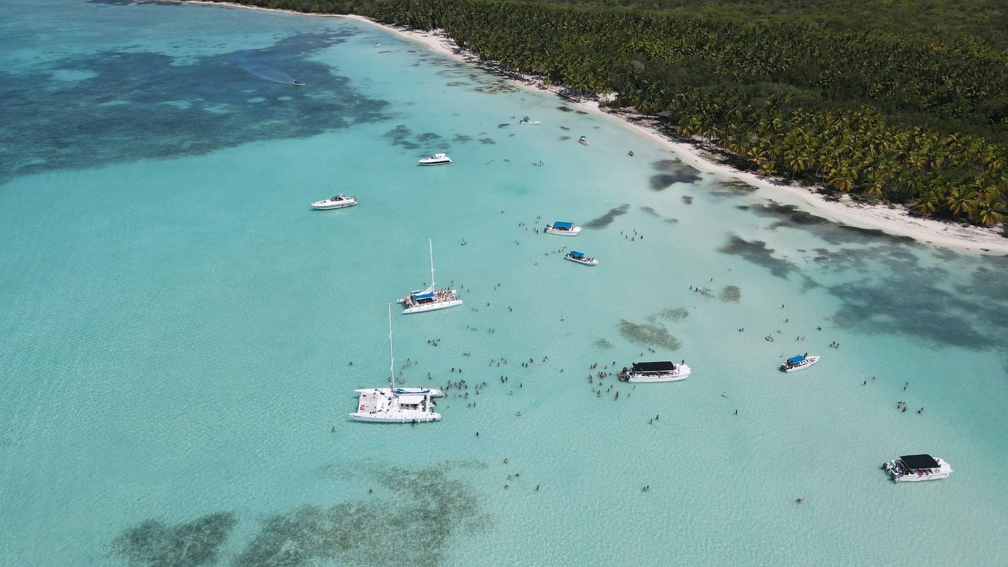 Tour boats moored in shallow turquoise water off Saona Island