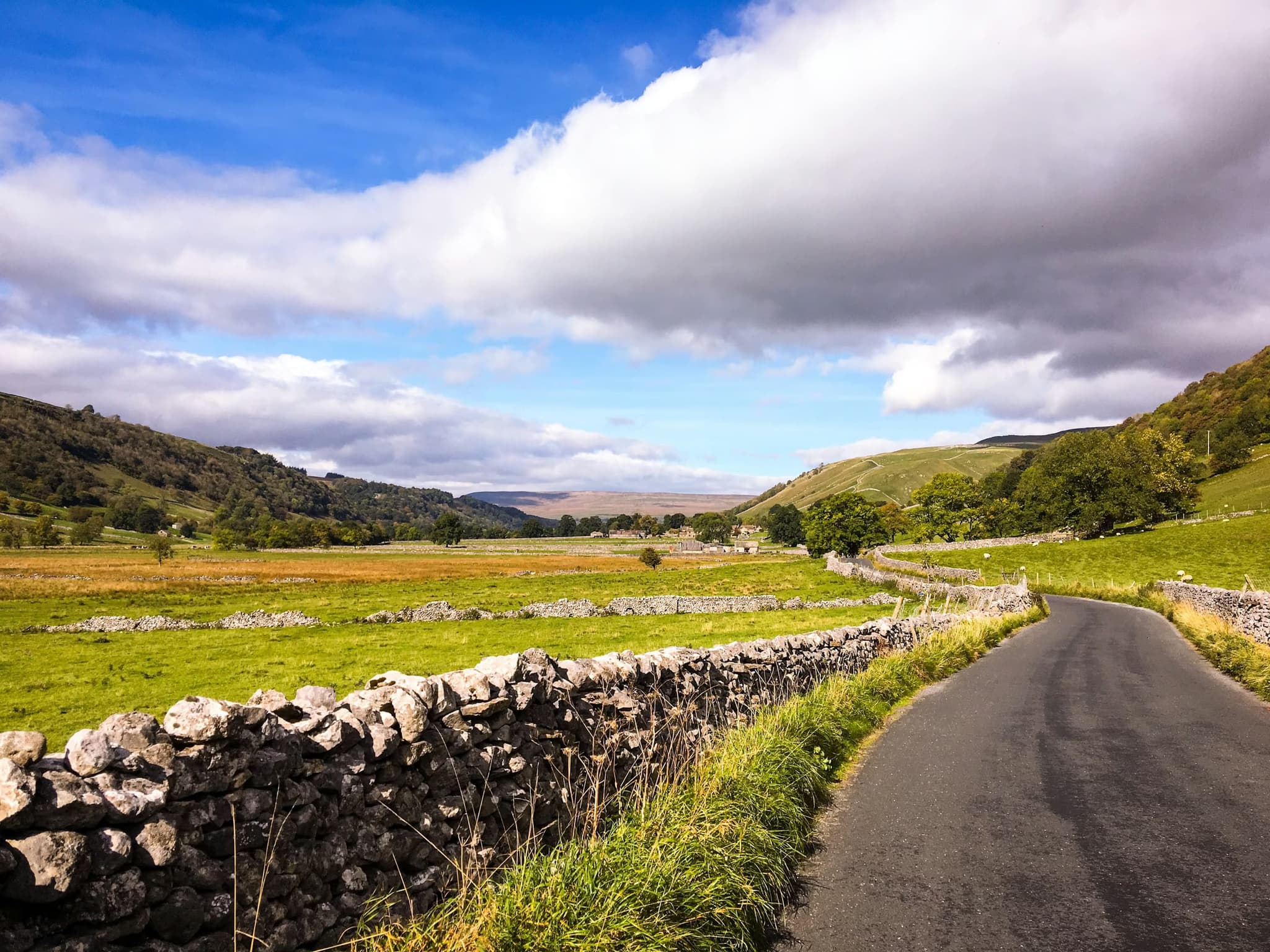 Green landscape and a road on a cloudy day in Yorkshire Dales