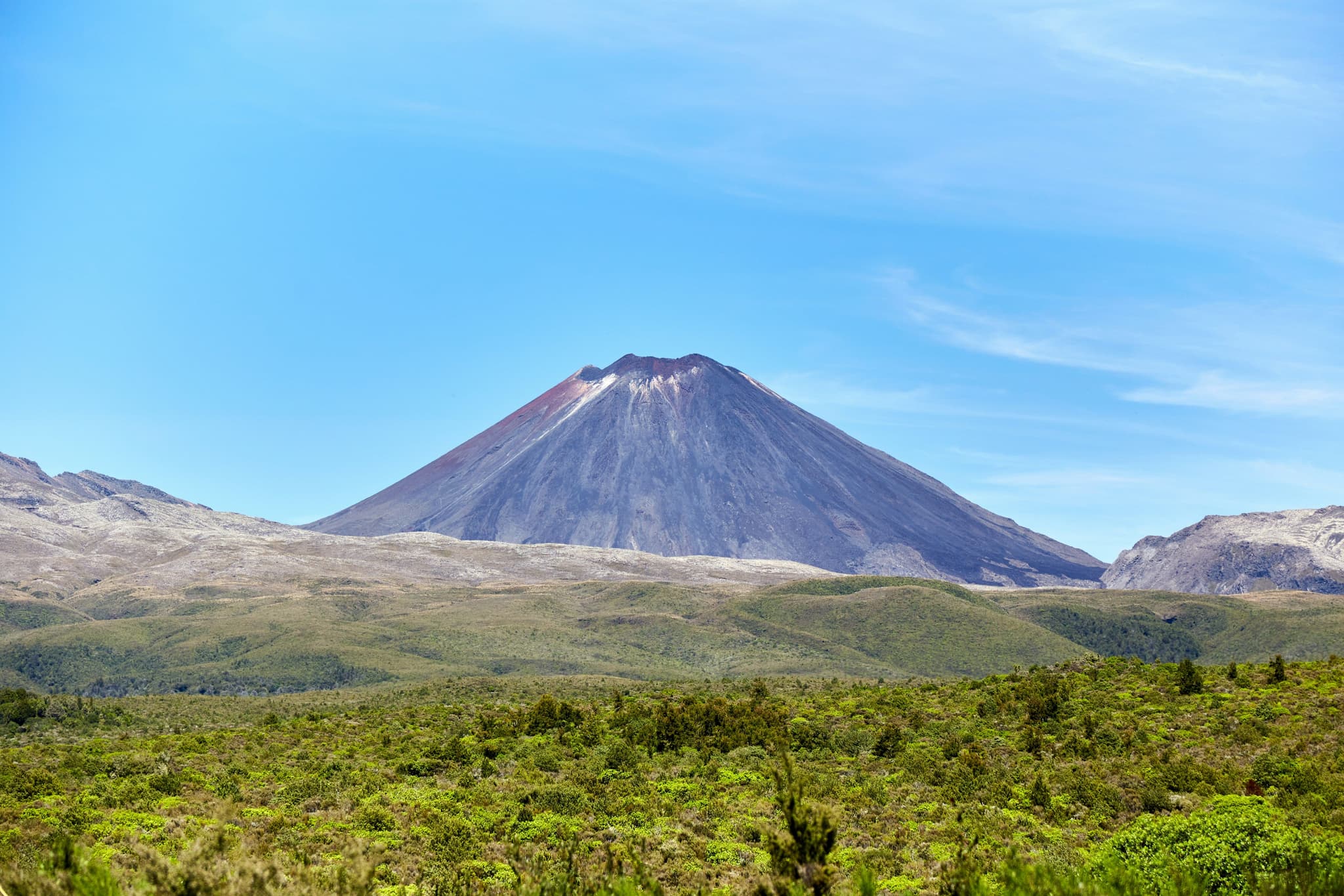 Ngauruhoe mountain in the distance surrounded by green grass