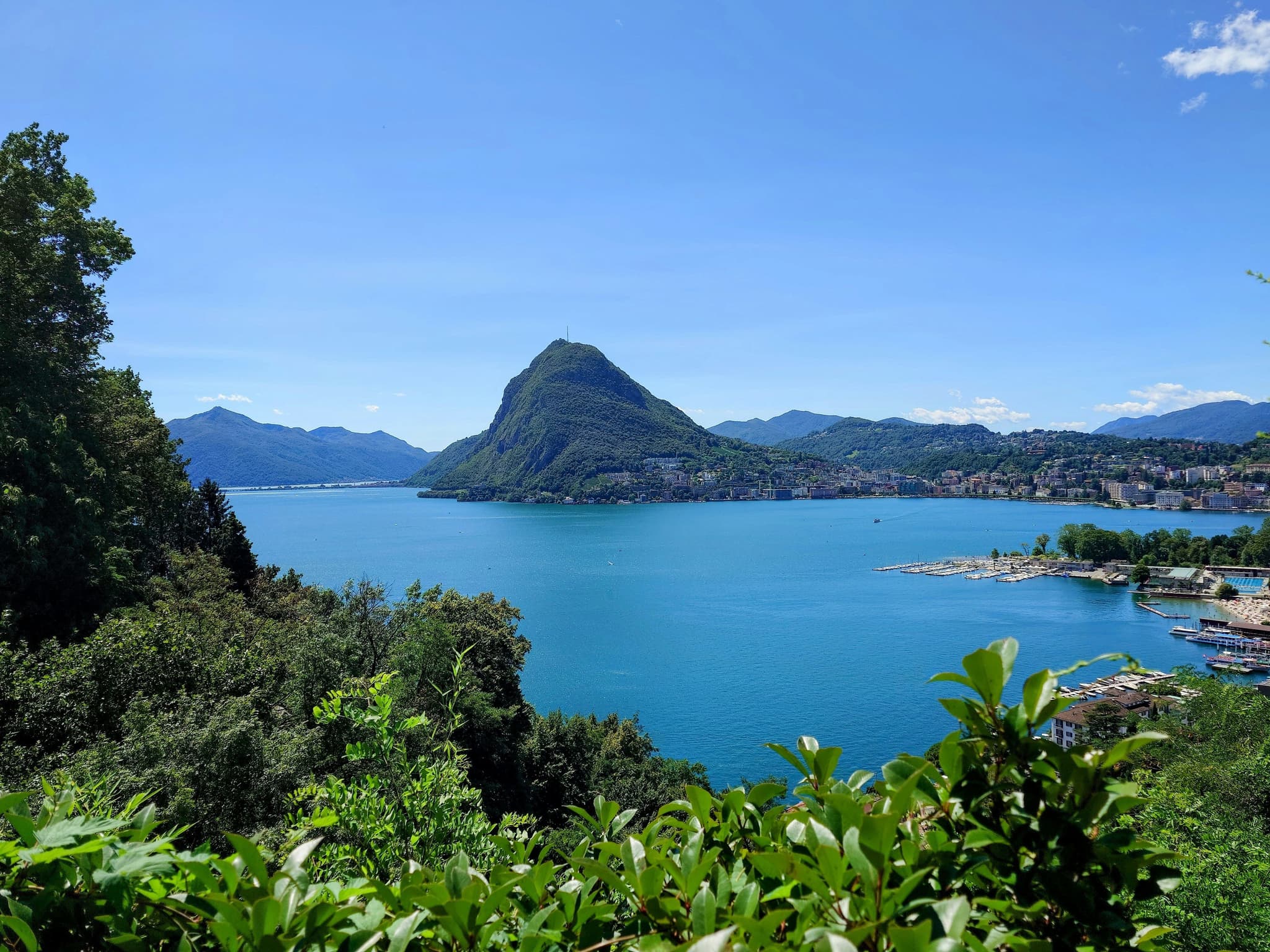 lake Lugano in switzerland surrounded by green trees