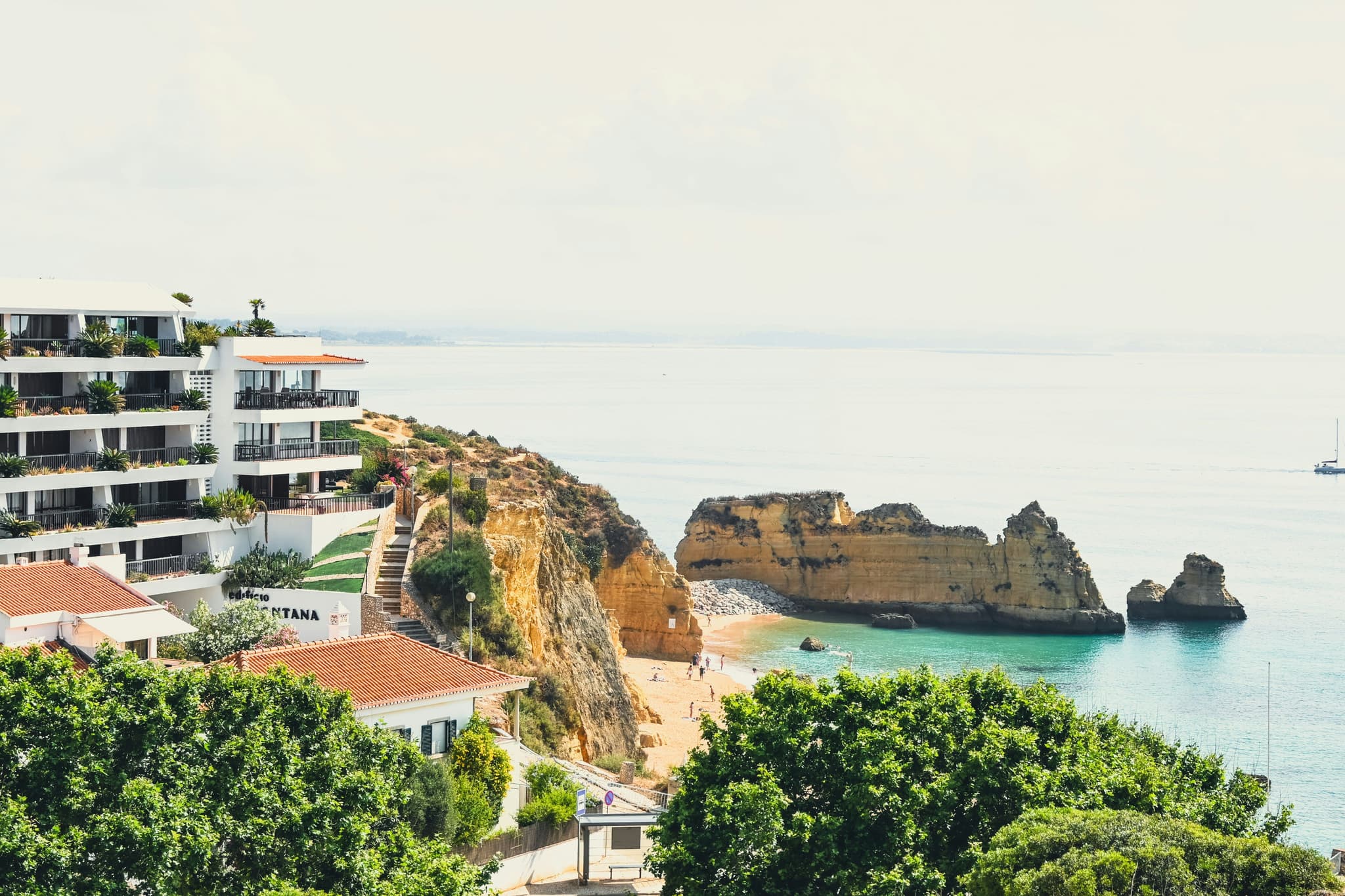 Hotel on a cliff in Algarve coast surrounded by turquoise water and rocks