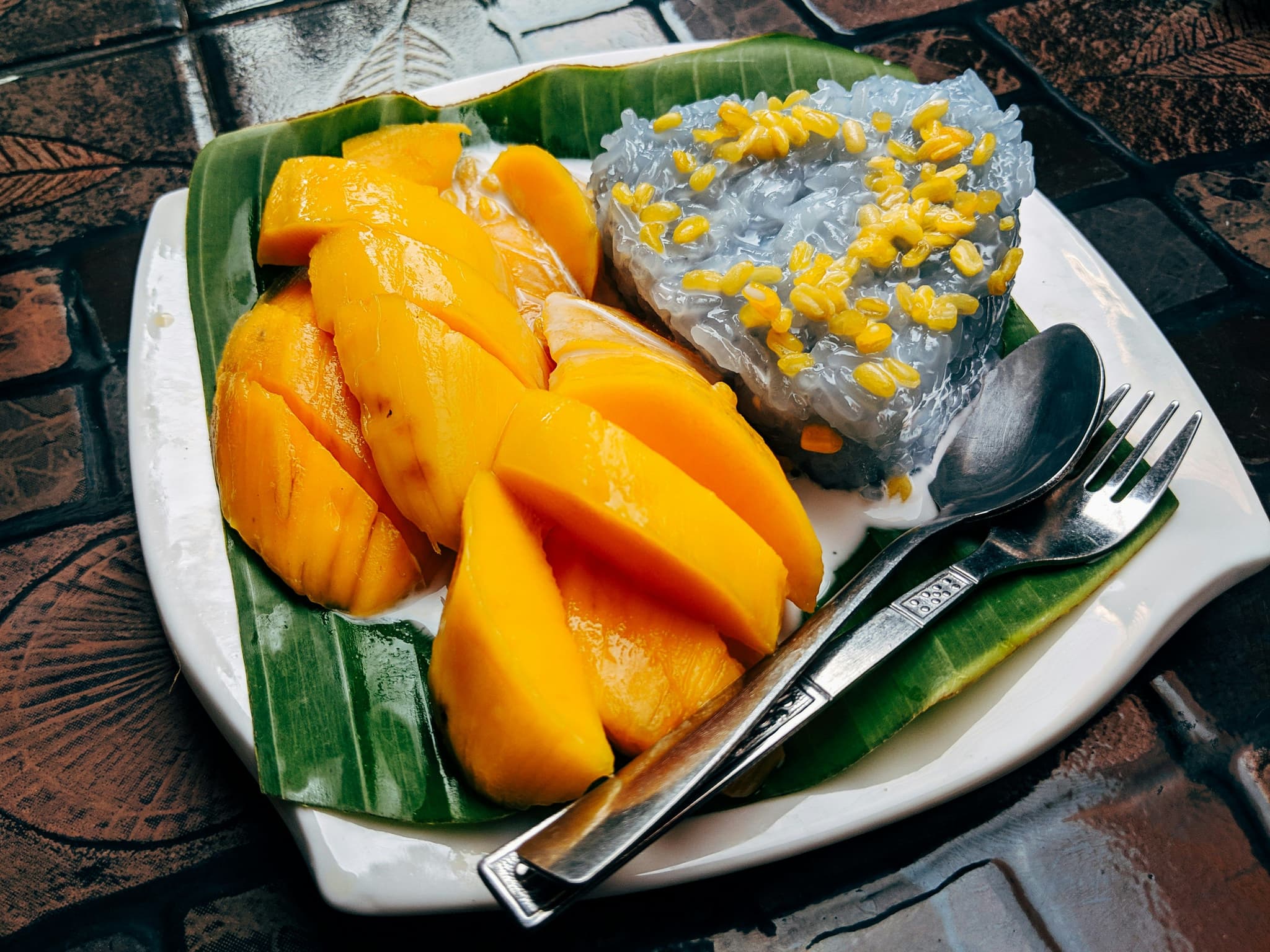 Mango sticky rice dessert served in banana leaves