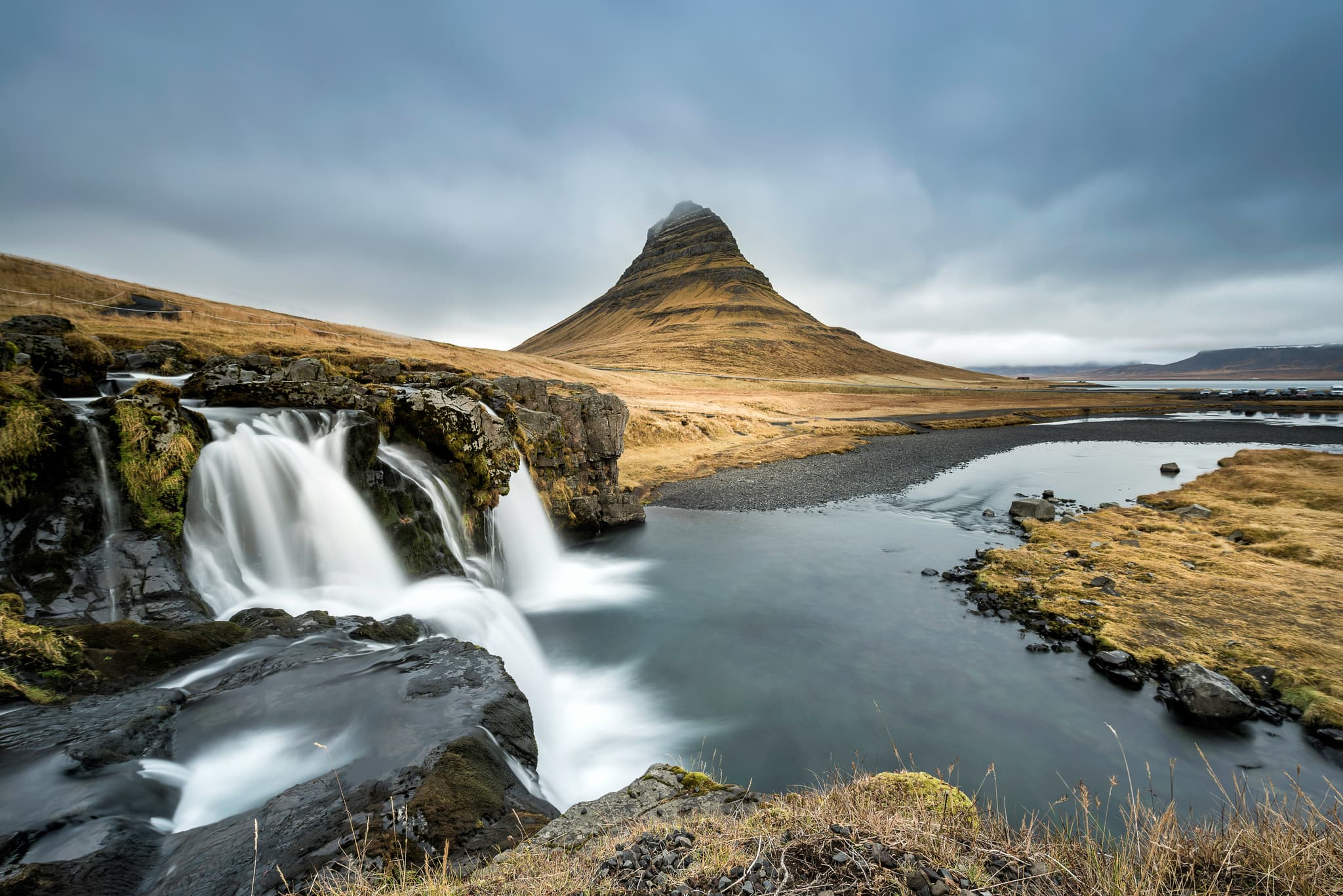 Kirkjufell mountain and waterfall and pool on a cloudy day