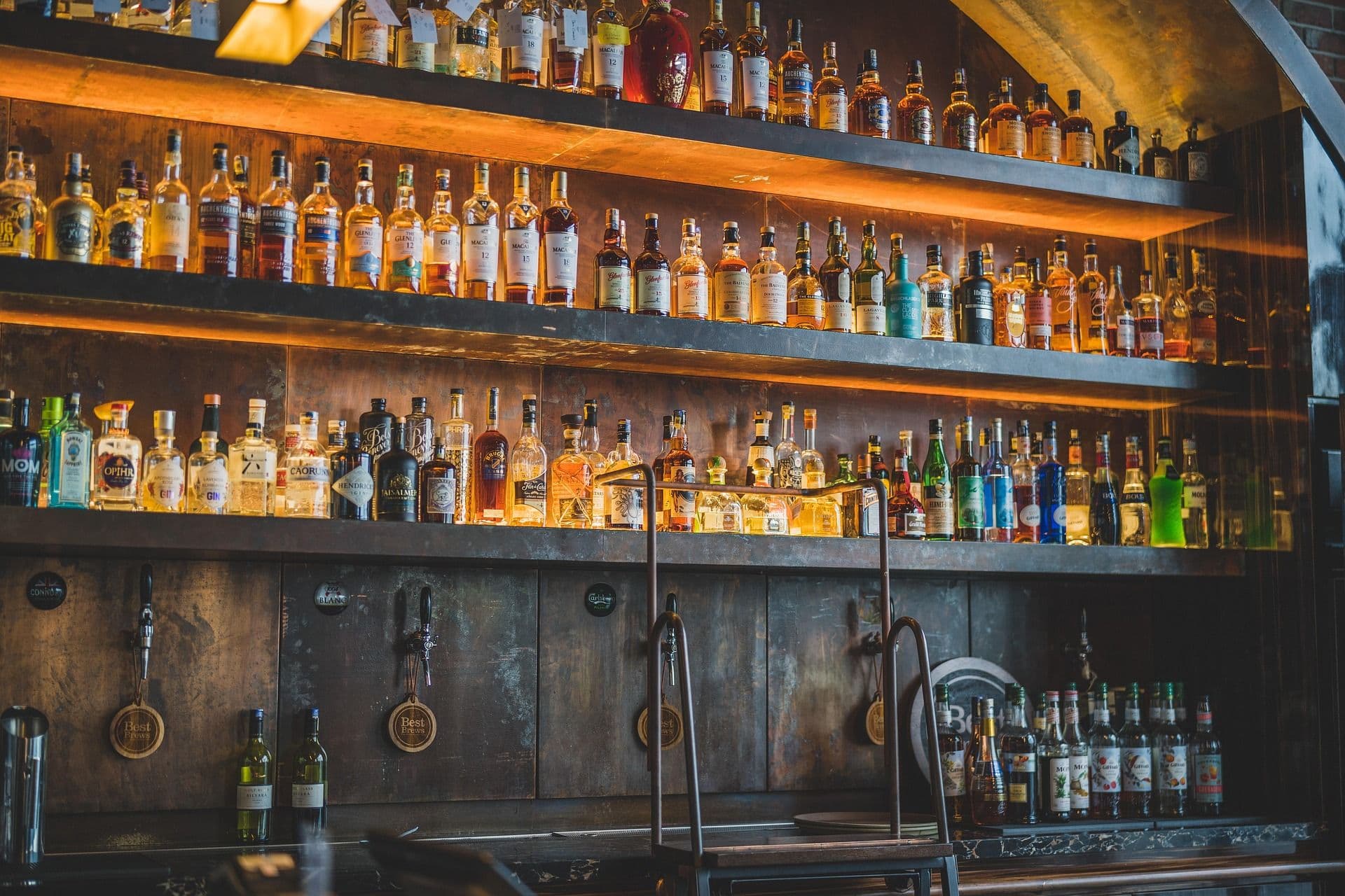 An authentic polish bar with wooden bartable and many bottles of alcohol on shelves