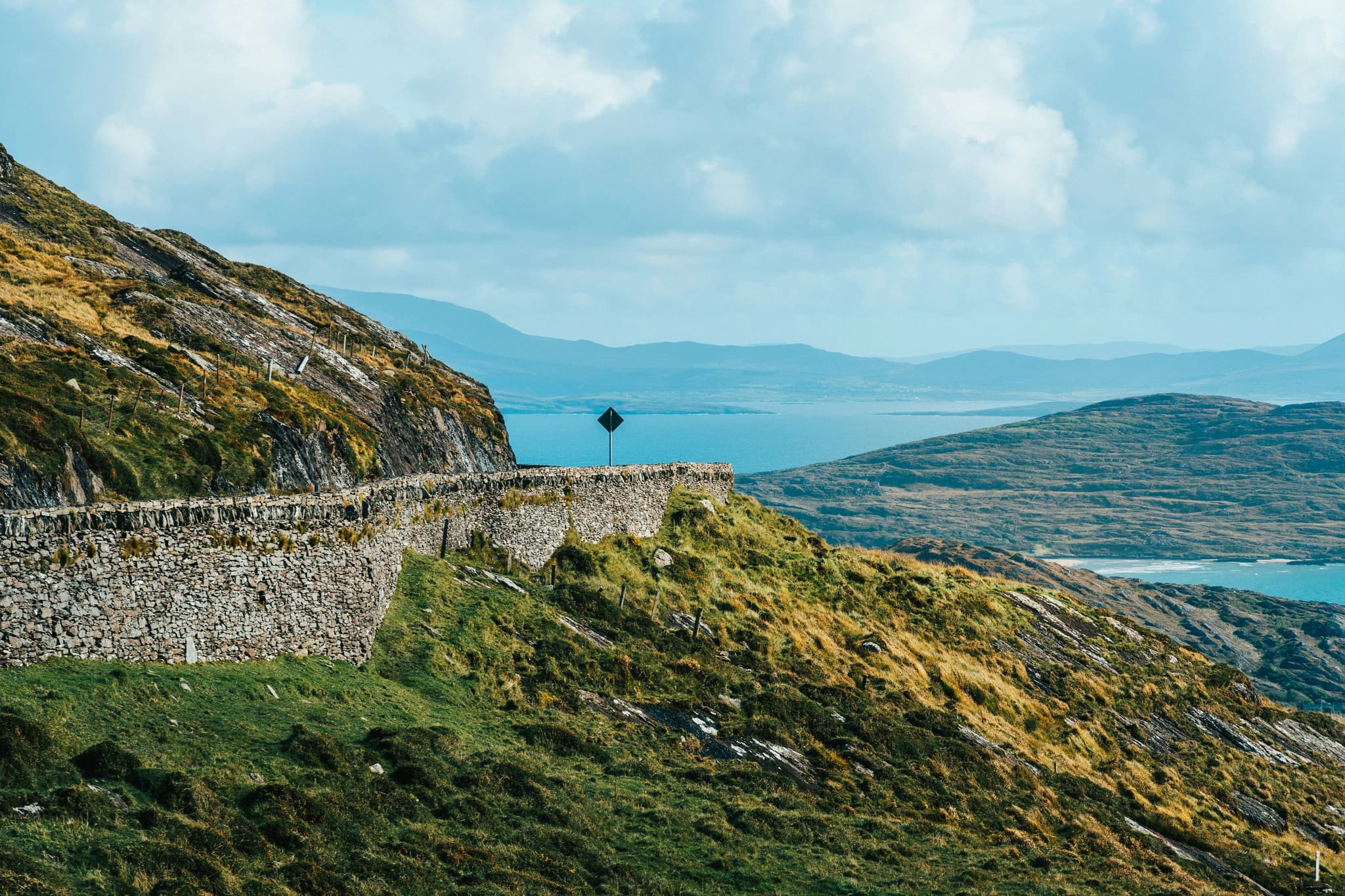 Green mountanous landscape with stone wall in the distance