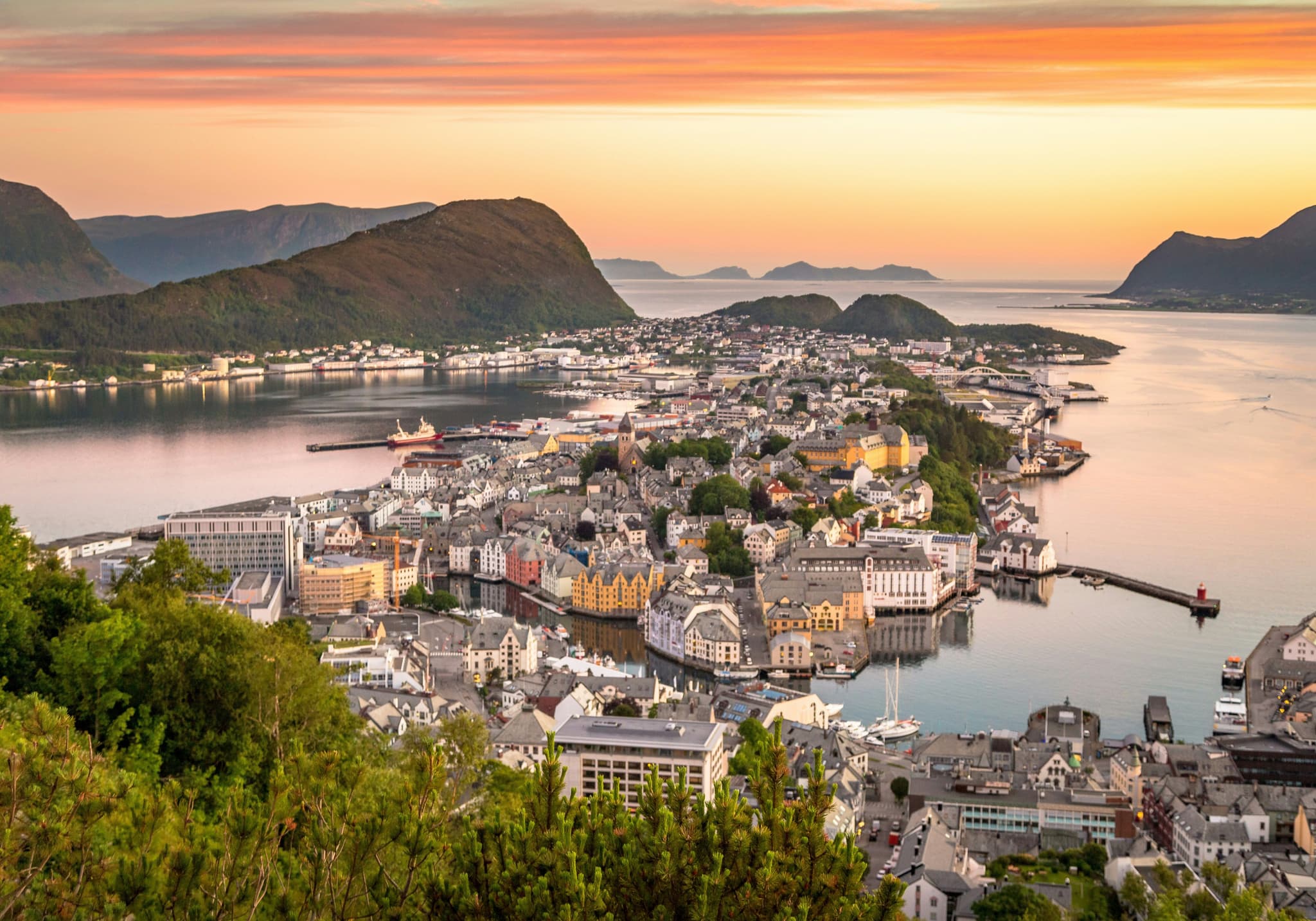 The city of Ålesund from above, islands in the water surrounded by mountains during sunset