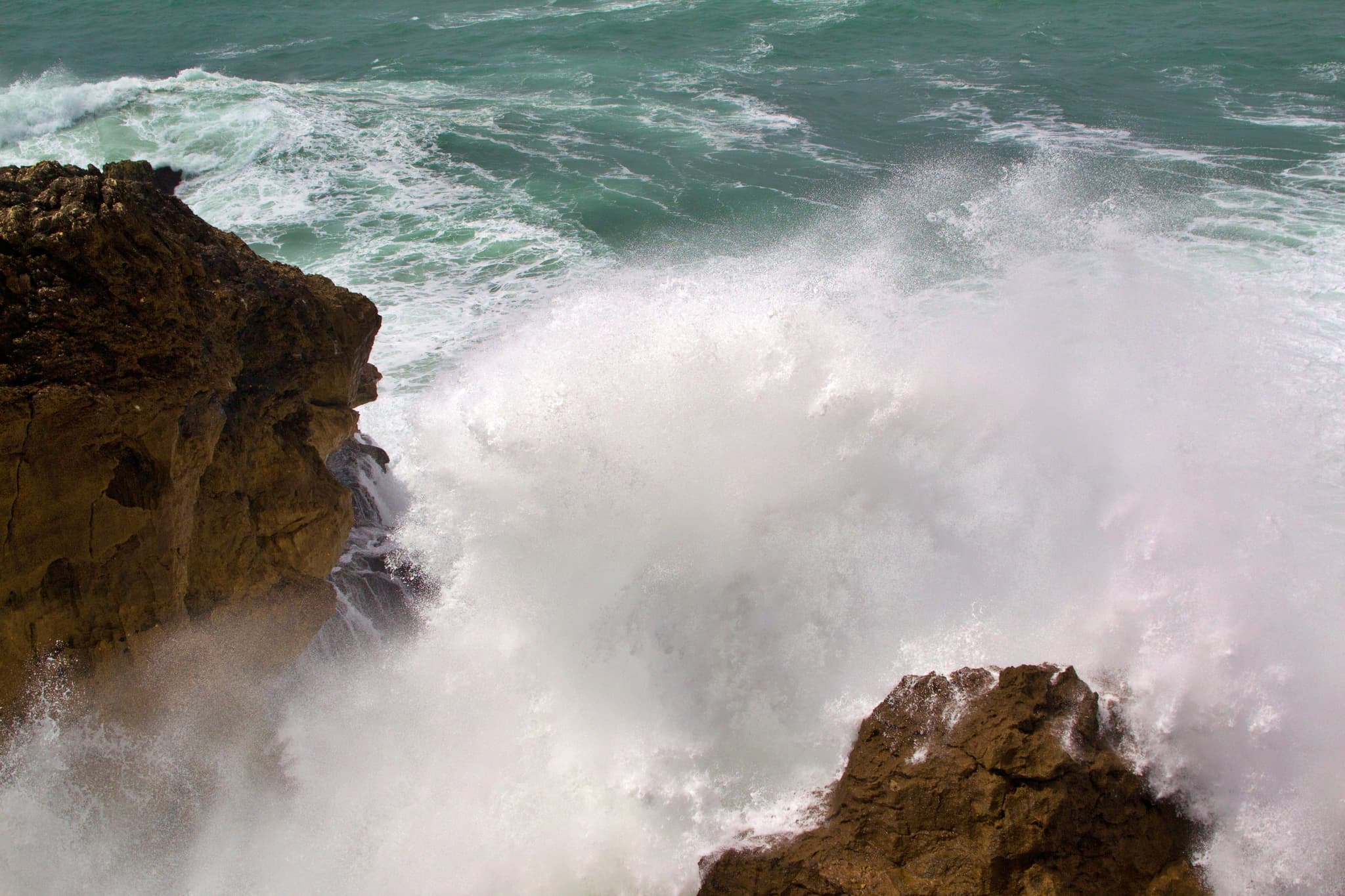 Big wave collapsing into cliff