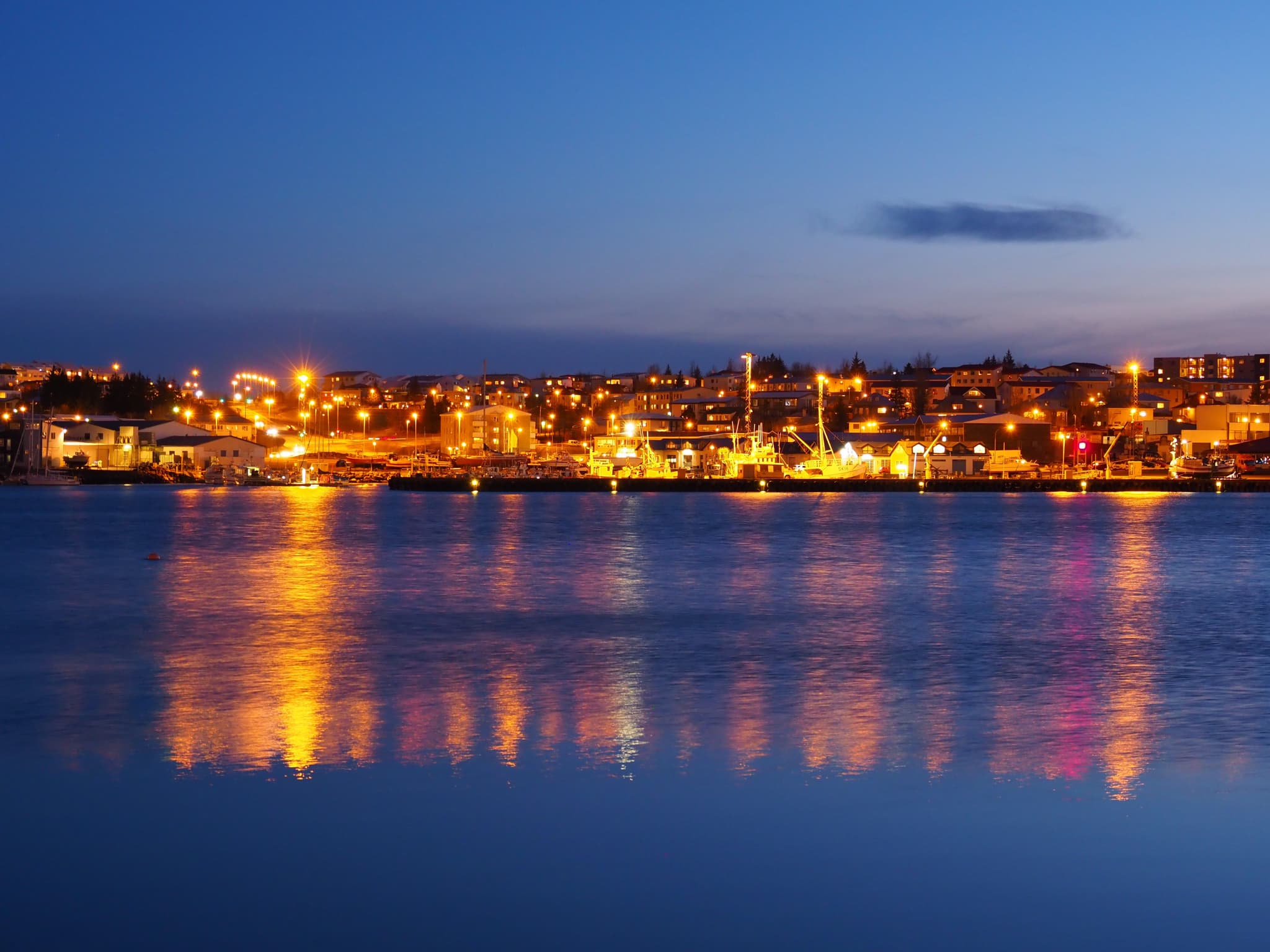 The harbour of Hafnarfjörður at night, well lit.