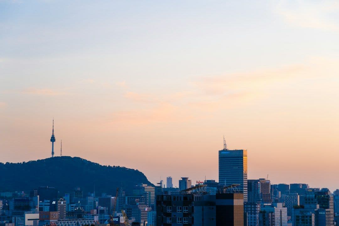 A city skyline in South Korea with mountains in the background.