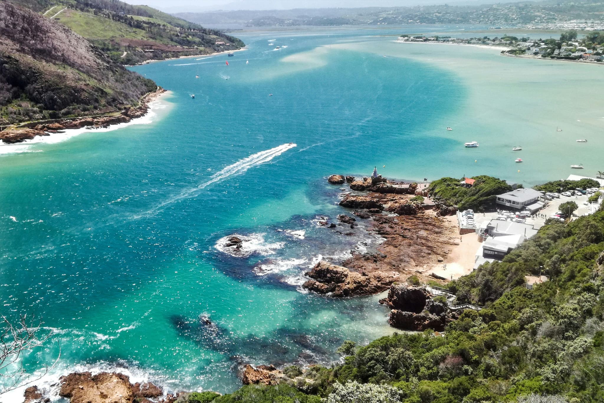 Blue turqoise water in Knysna Lagoon with green mountains