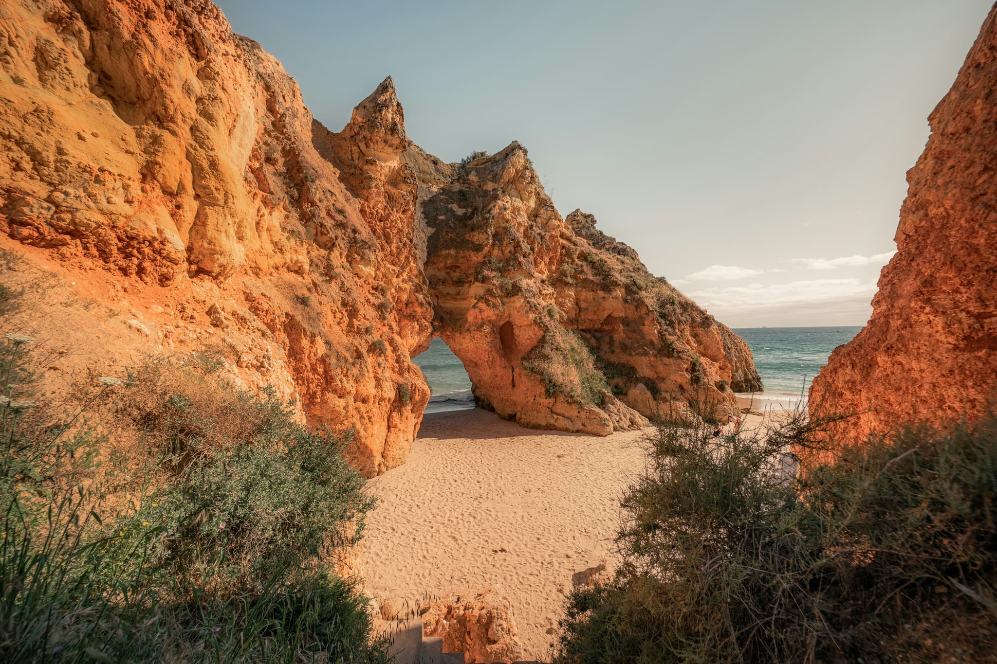 Golden limestone cliffs, sandy beach and turquoise water along the Algarve coast in Portugal