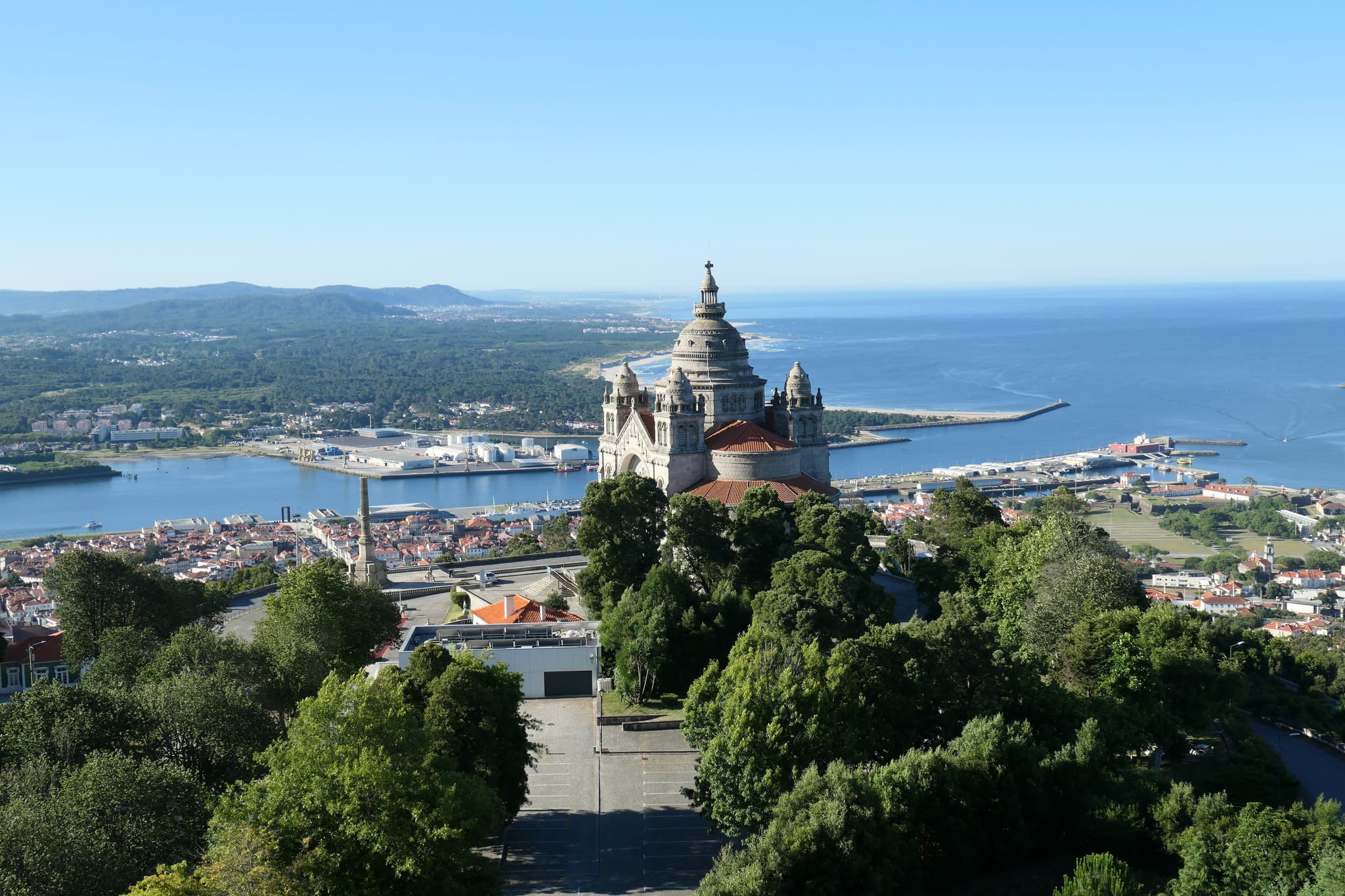A view from above looking at trees and the sea surrounding Santa Luzia Basilica